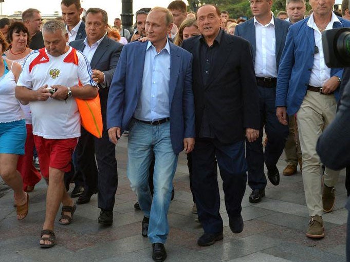 Vladimir Putin and Silvio Berlusconi walking along a seaside esplanade in Yalta, Crimea