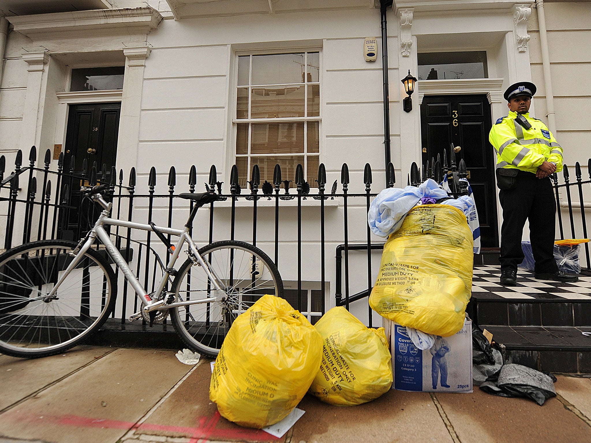 A police officer stands guard outside the Pimlico flat where Mr William's body was discovered