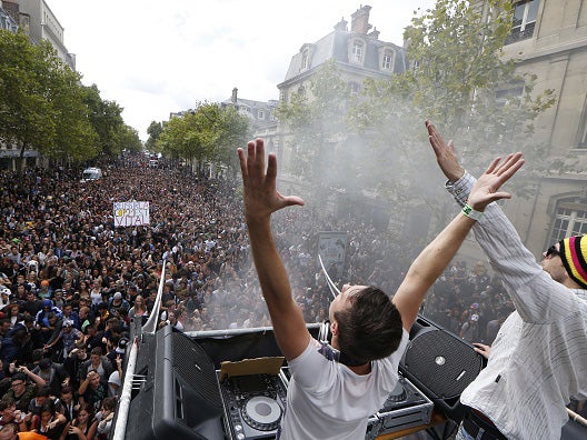 DJ's gesture to the crowd during the 17th edition of the Techno Parade music event in Paris