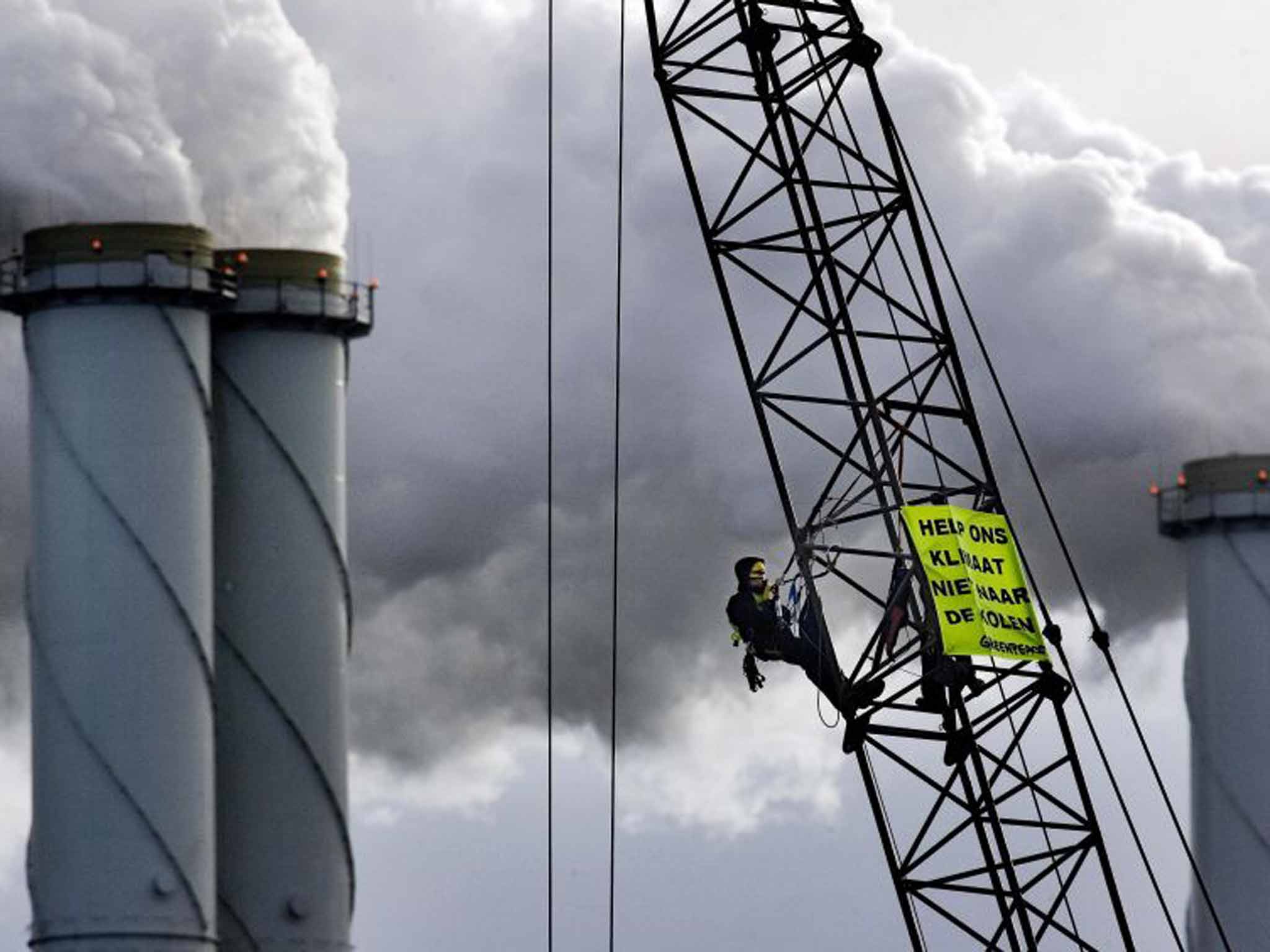 Greenpeace activists chained to a crane protest at the construction of a coal-fired power plant in Rotterdam