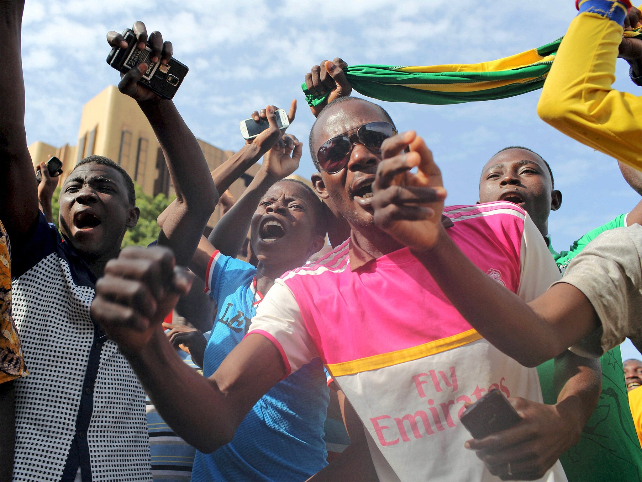 Anti-coup protesters sing the country’s national anthem in Burkina Faso’s capital