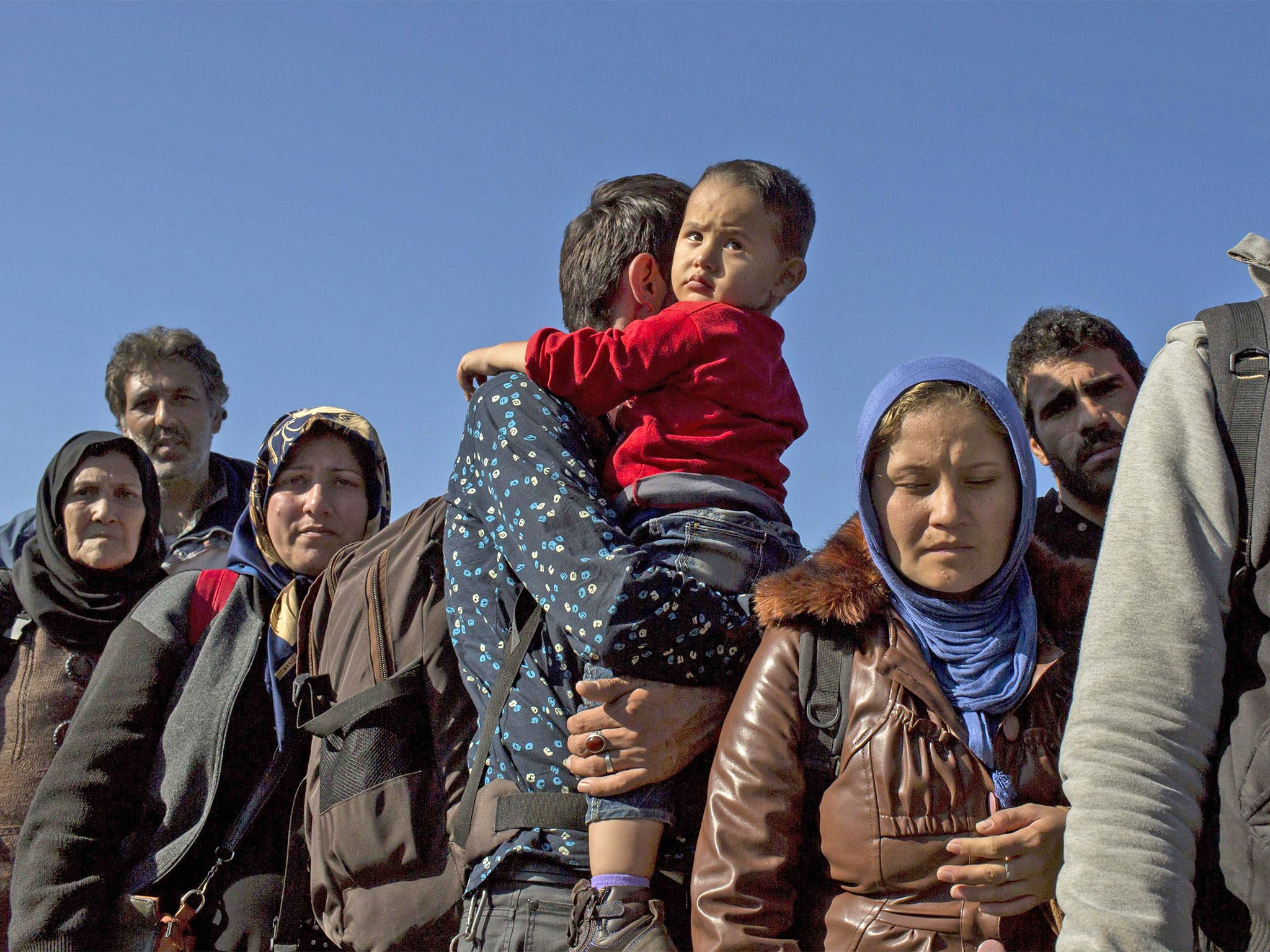 Refugees stand in line to enter a registration camp in Opatovac, Croatia