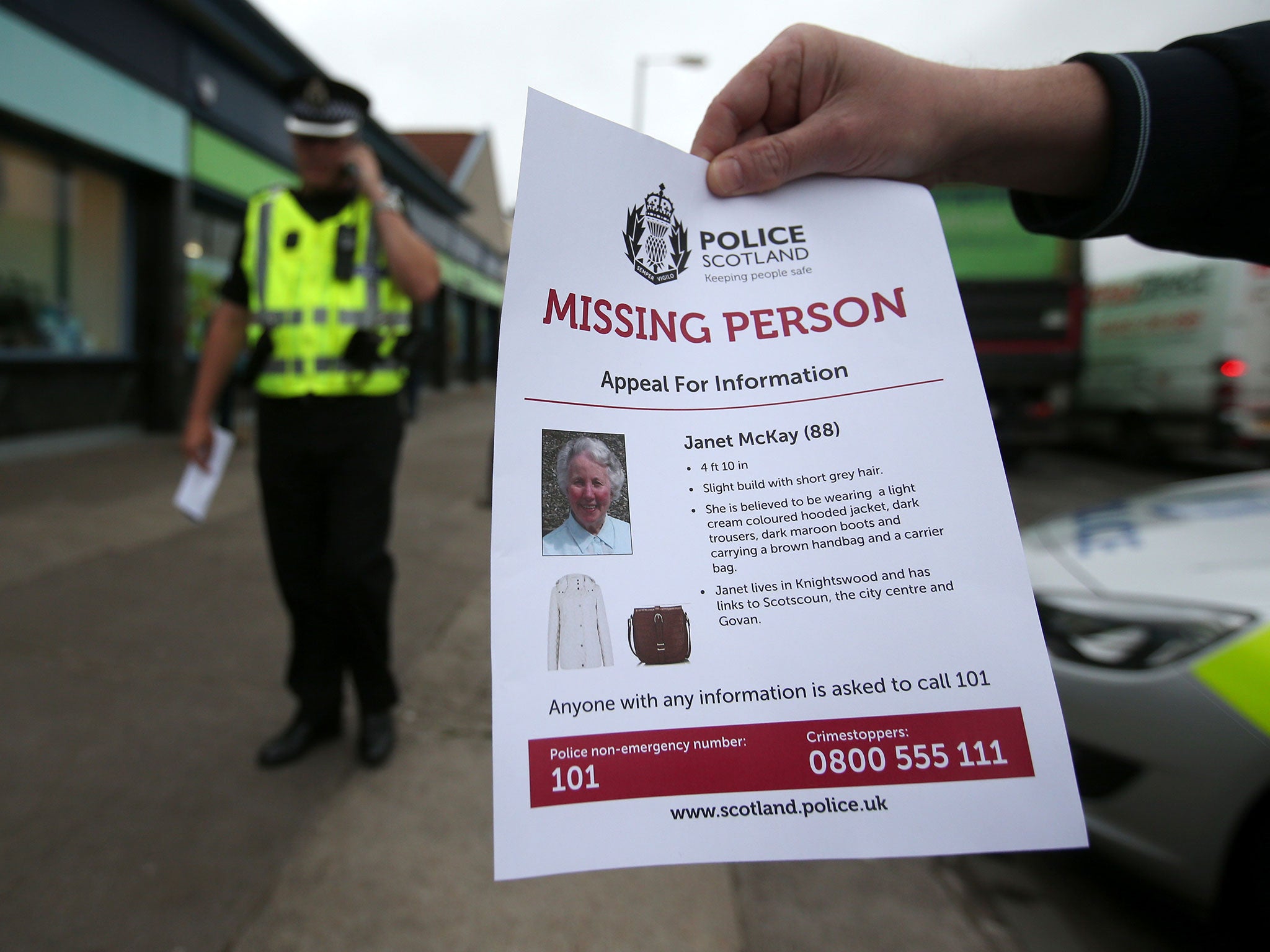 Police handing out leaflets on Alderman Road in Glasgow as they search for Janet McKay, 88