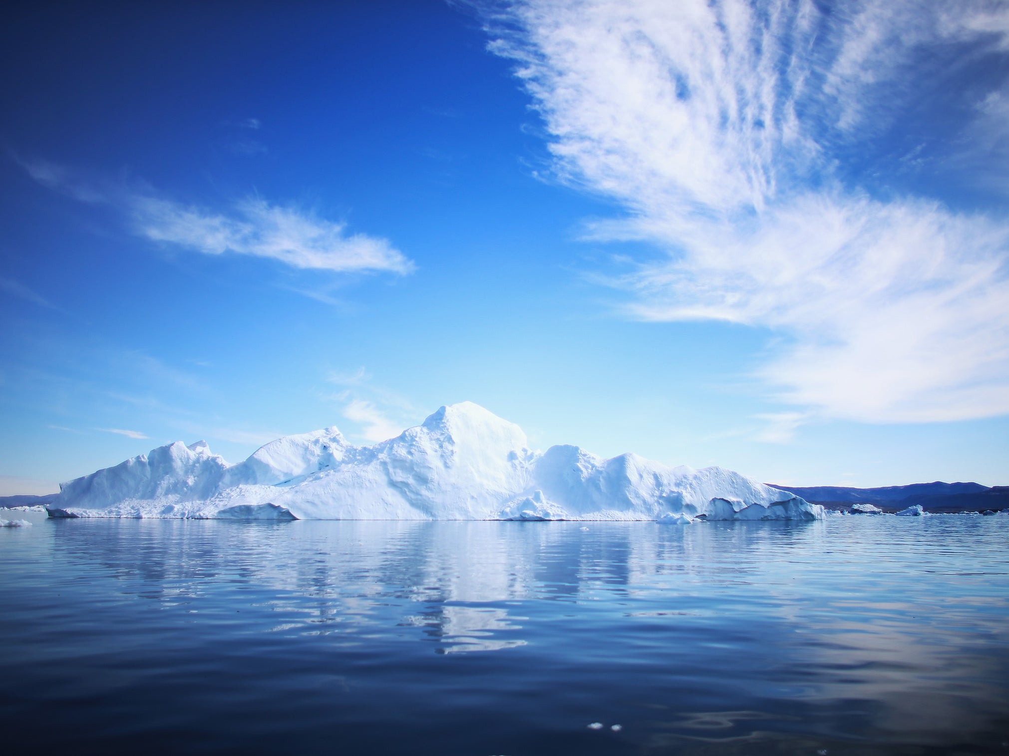 A boat is seen seen among the icebergs that broke off from the Jakobshavn Glacier as the sun reaches its lowest point of the day on July 23, 2013 in Ilulissat, Greenland