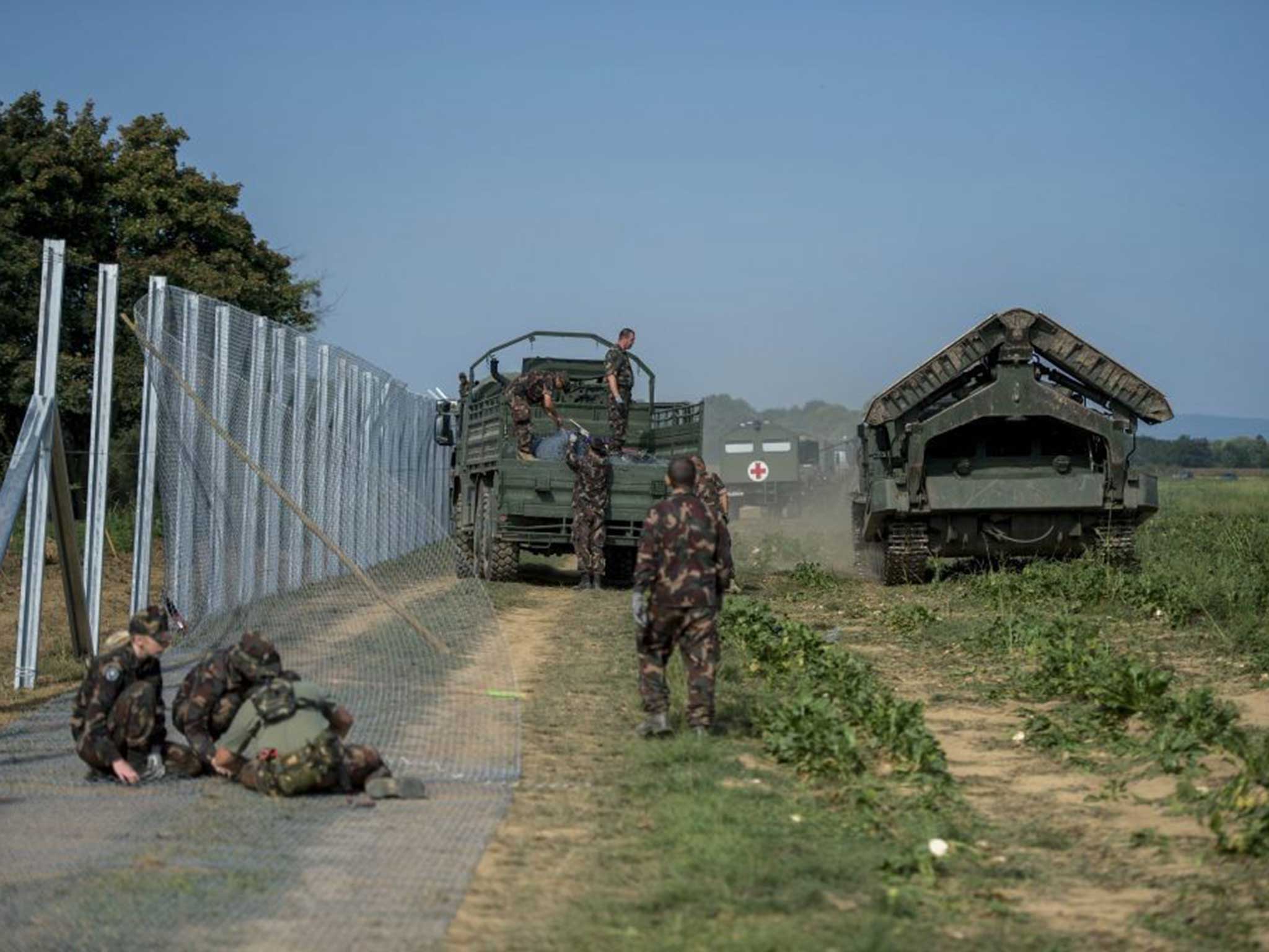 Soldiers work on the fence along the now-finished Croatian border