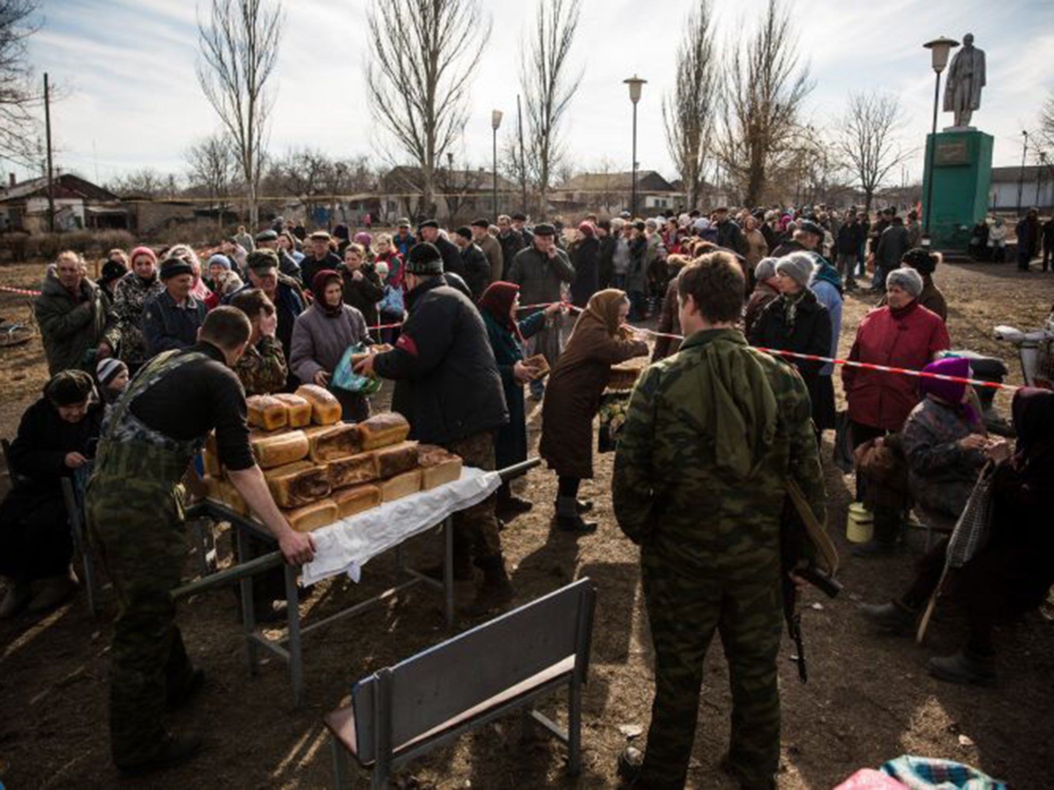 Civilians in the damaged village of Chornukyne are given bread