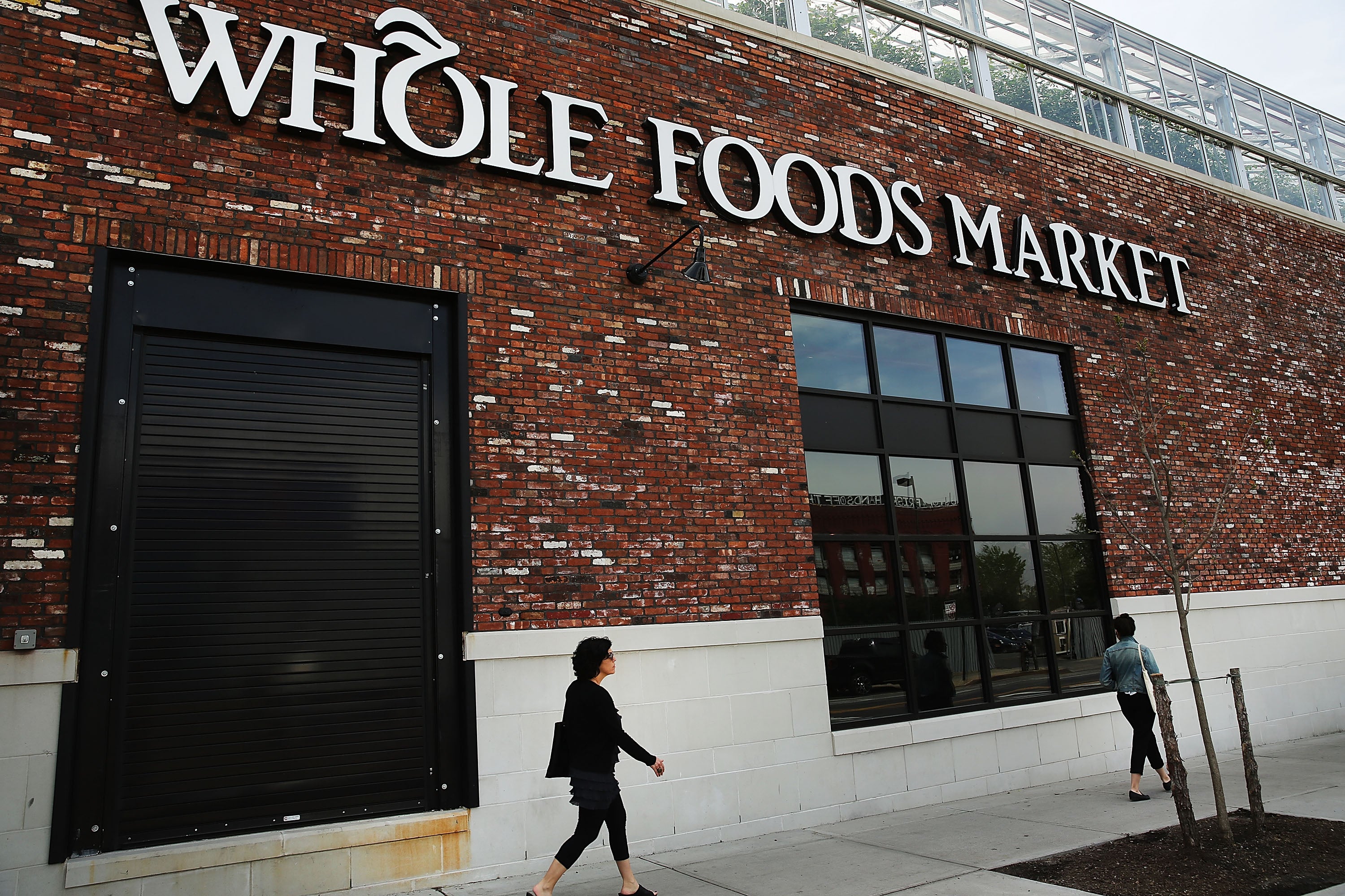 People walk past a Whole Foods Market in Brooklyn.