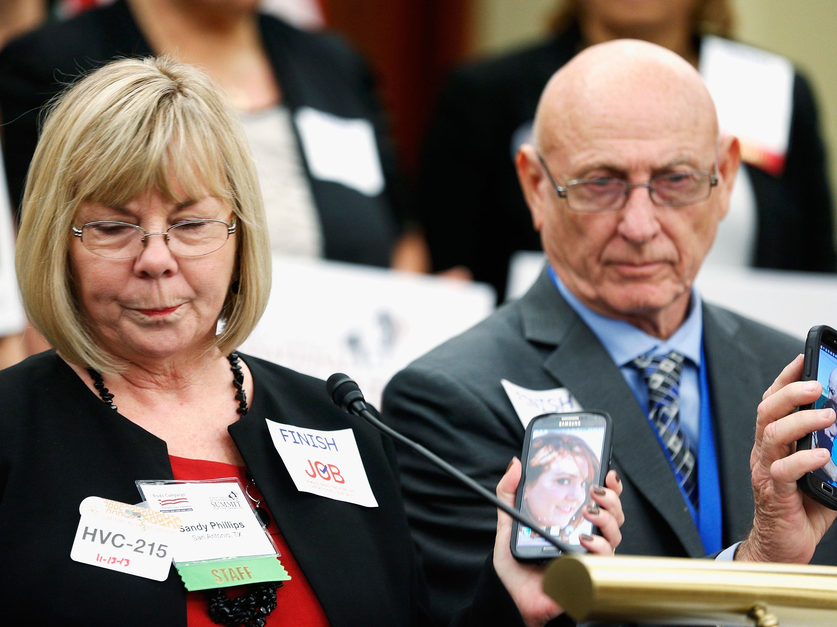 Sandy Phillips and her husband Lonnie Phillips hold up photos of their daughter Jessica, who was killed in the Aurora, Colorado movie theater shooting in July of 2012