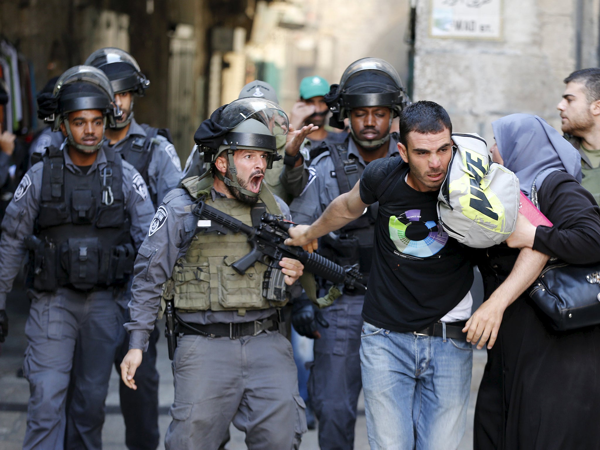 An Israeli policeman prevents a Palestinian man from entering the compound which houses al-Aqsa mosque, known by Muslims as the Noble Sanctuary and by Jews as the Temple Mount, in Jerusalem's Old City