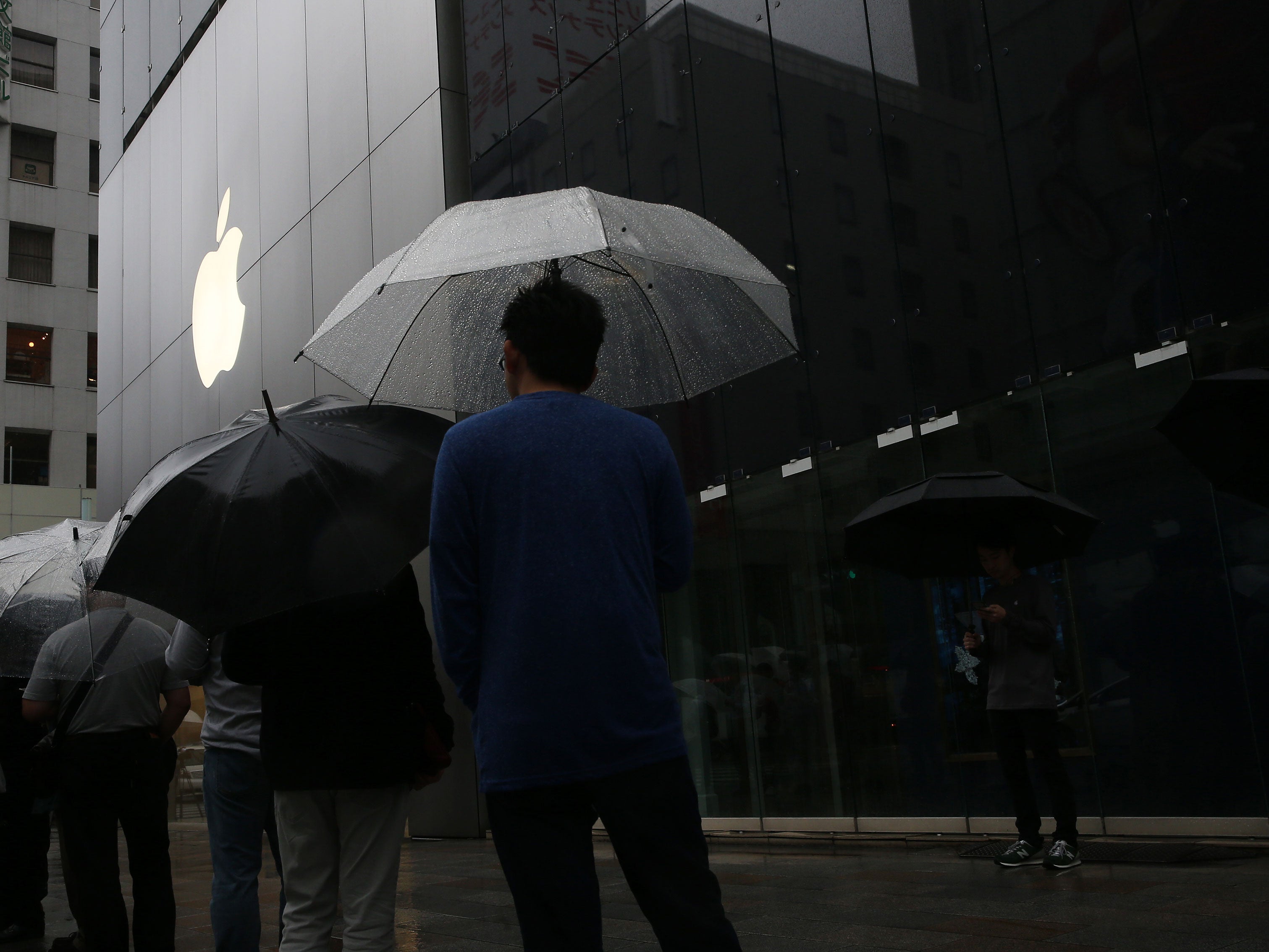 Customers queue to purchase the new iPhone 6s and 6s Plus in front of Apple Ginza store on September 25, 2015 in Tokyo, Japan