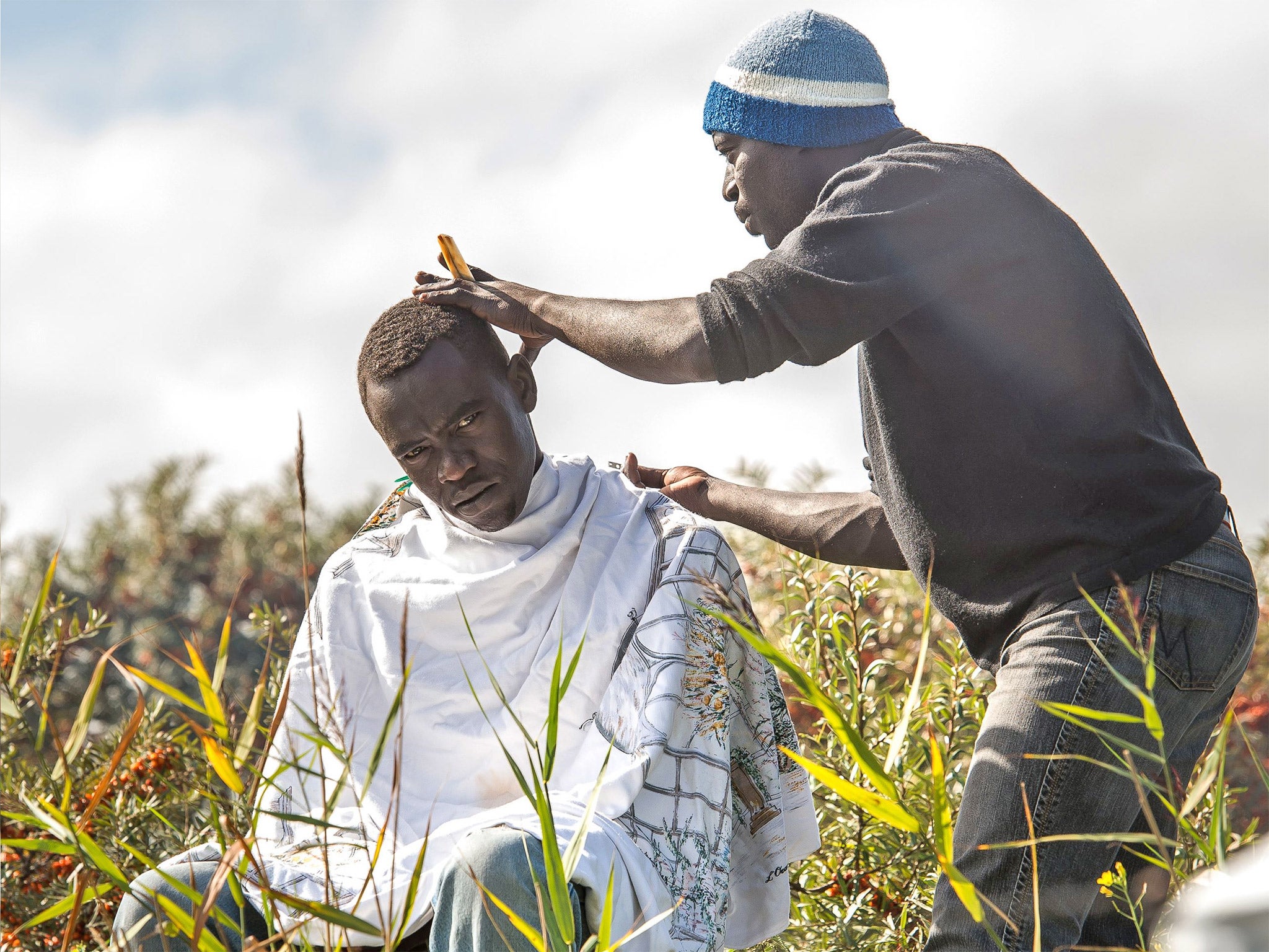 One of the refugees has his hair cut