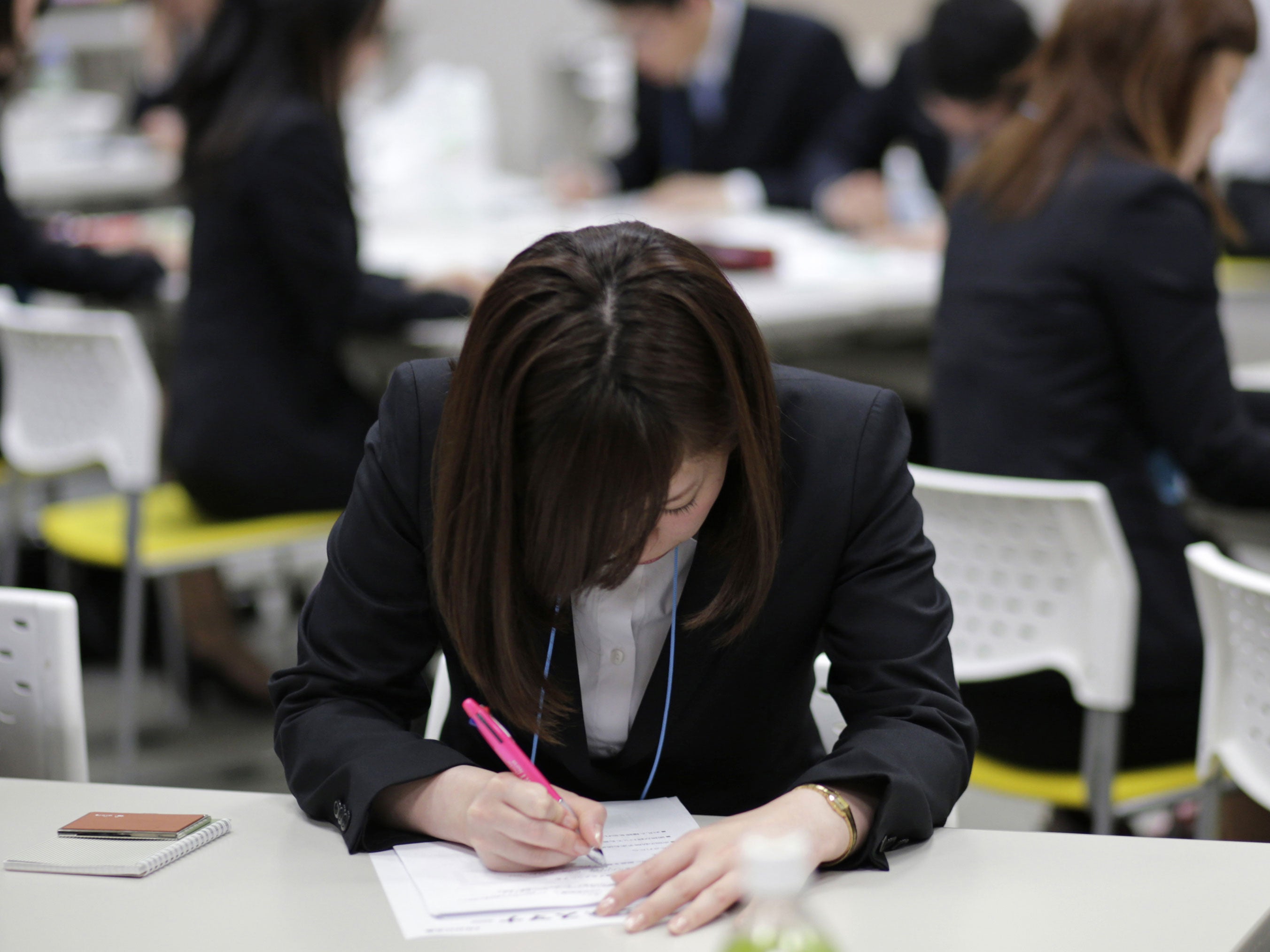 Japanese job-hunting students dressed in suits attend a business manners seminar at a placement centre in Tokyo May 28, 2012.