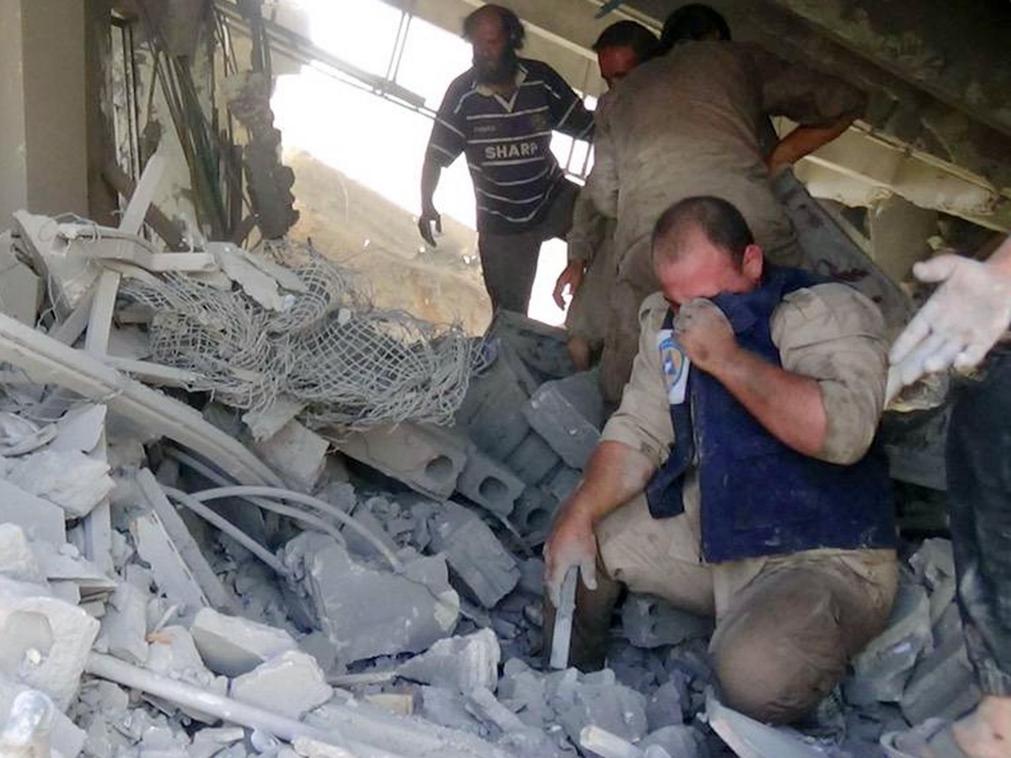 Volunteers from Syria Civil Defence, also known as the White Helmets, help civilians after Russia carried out its first airstrikes in Syria