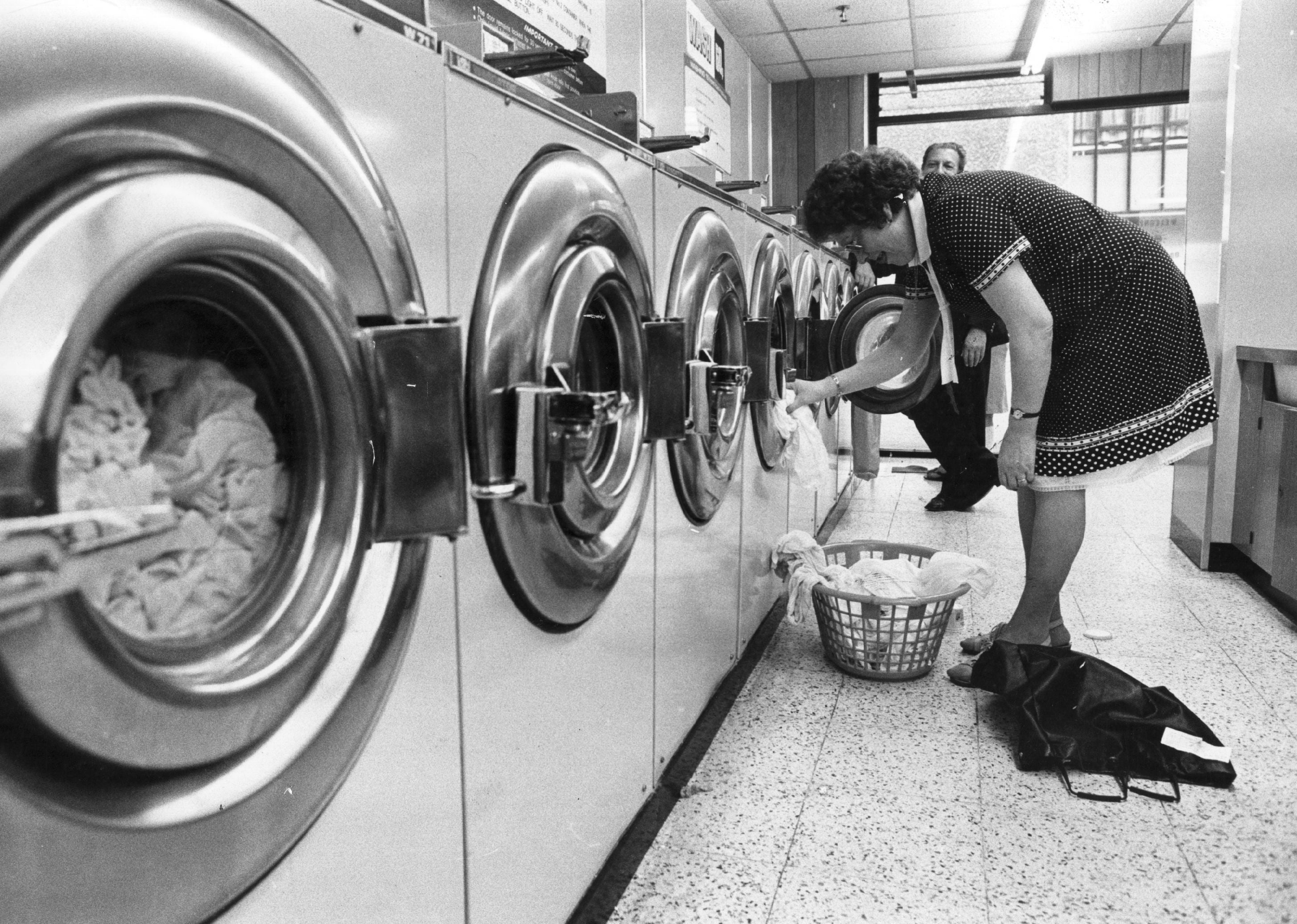 A woman loads laundry at a London launderette