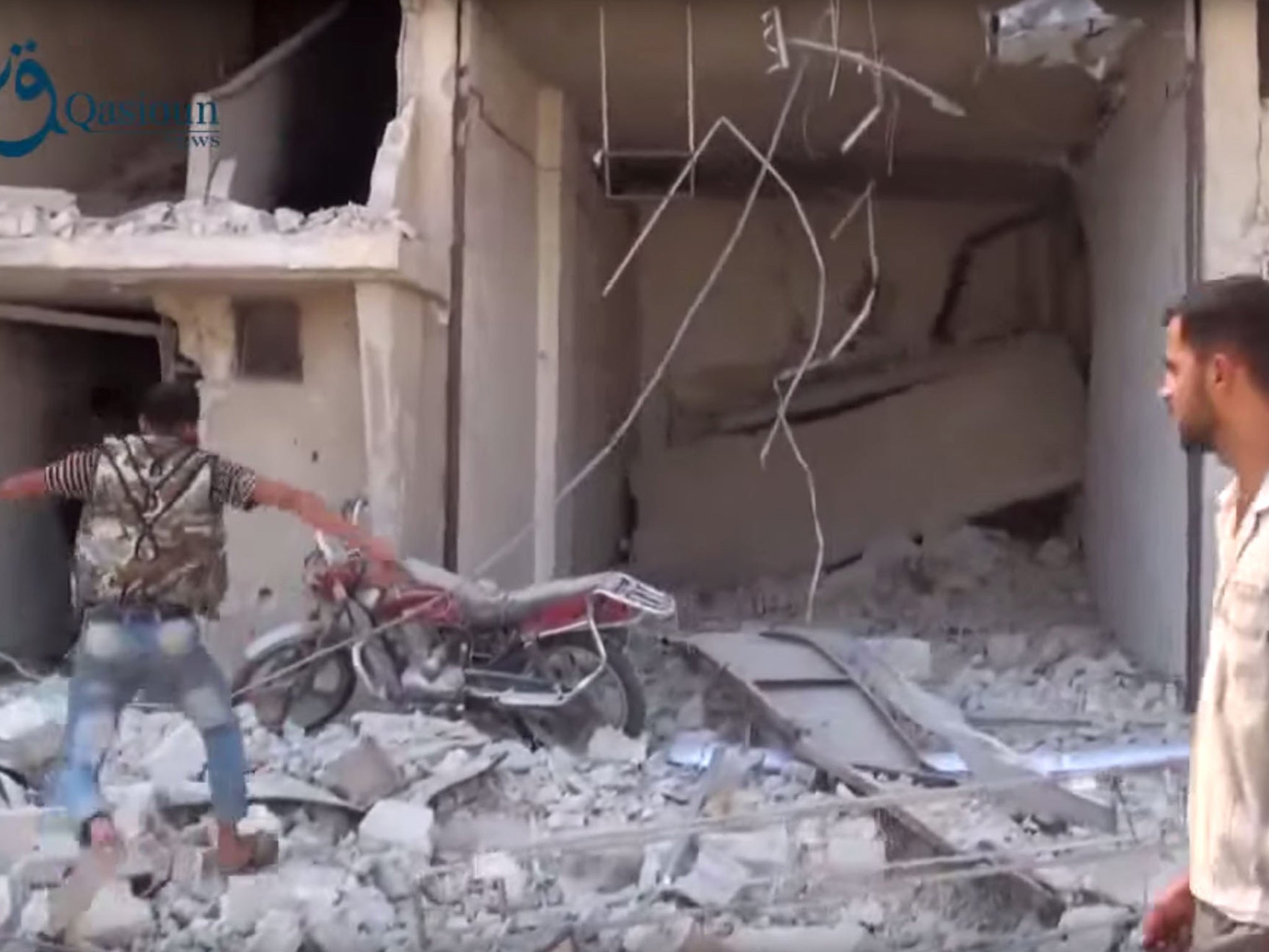 Syrians gather near the rubble of a building, in the aftermath of a Russian airstrike, in Dair al-Asafeer village, rural Damascus