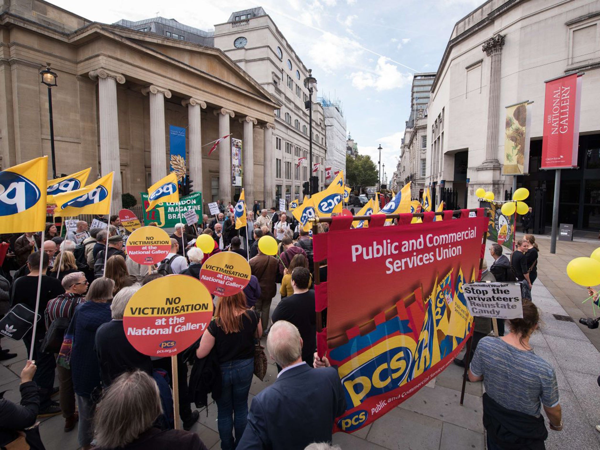 Demonstraters hold yellow balloons and home-made sunflowers outside the National Gallery in London on September 24, 2015, during a protest to mark 100 days since the beginning of strike action