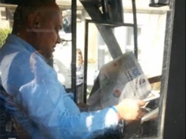 The bus driver is seen pulling out a copy of the Metro newspaper The Bath Chronicle/ Facebook