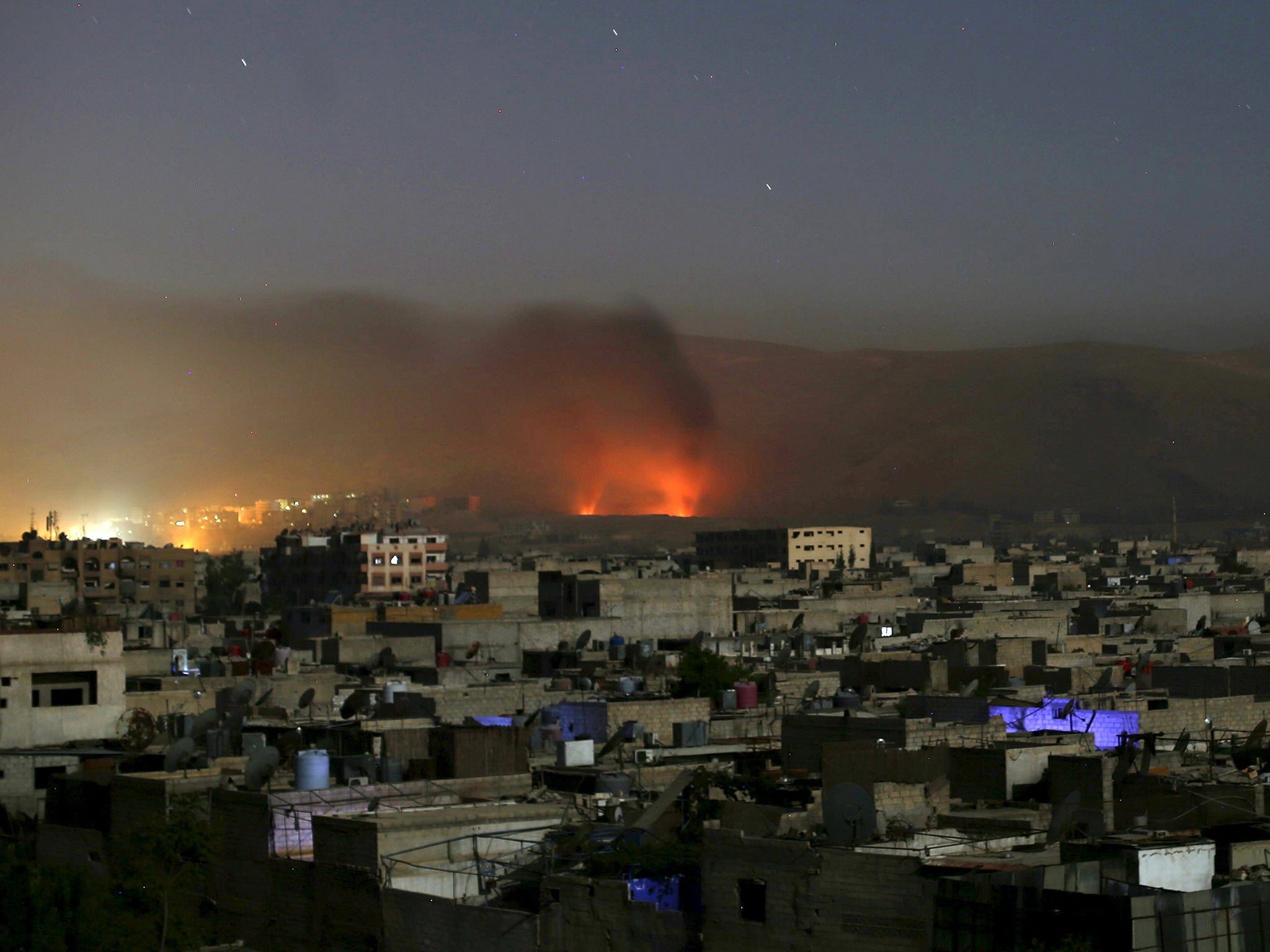 Smoke rises during clashes between forces loyal to Syria's President Bashar al-Assad and the Army of Islam fighters, on the eastern mountains of Qalamoun overlooking the town of Douma