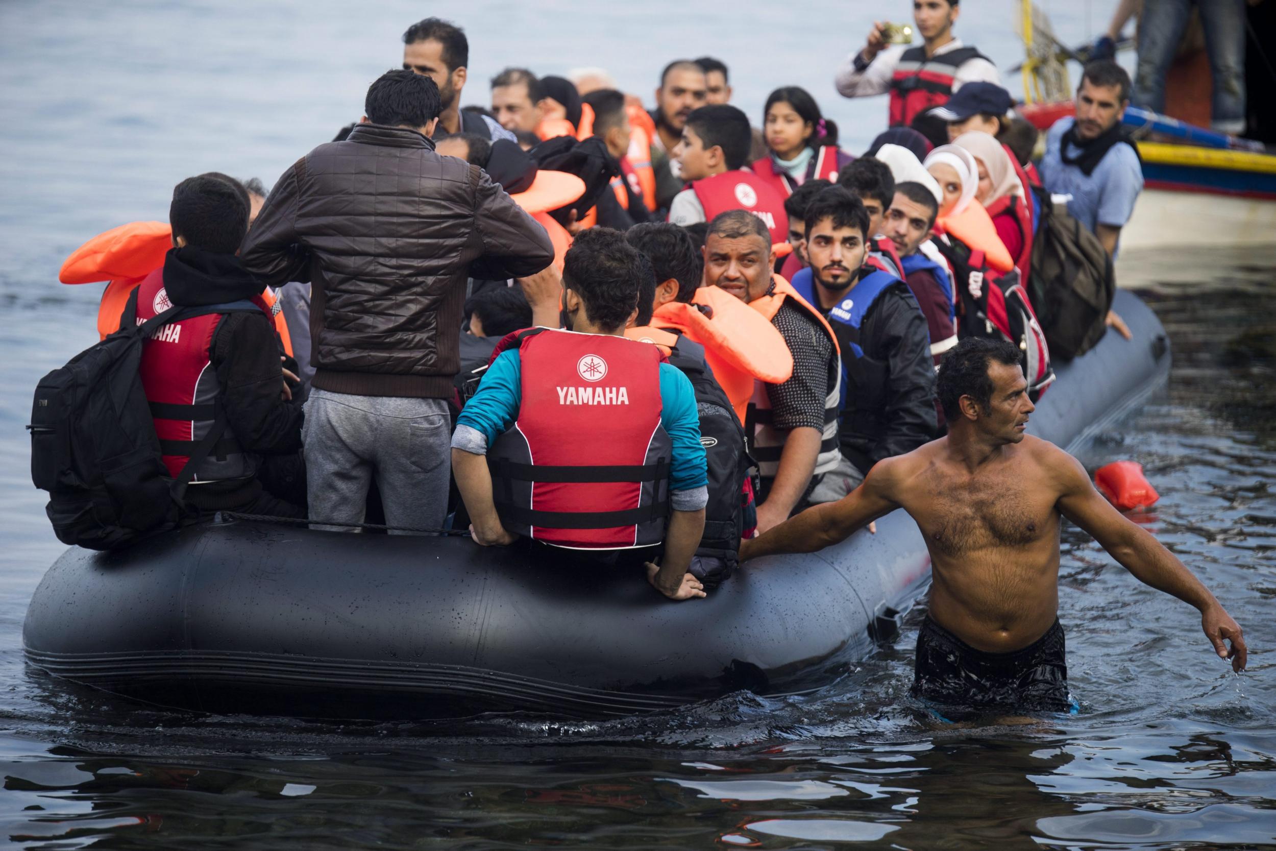 Refugees traveling by overloaded rubber dinghy from Turkey arrive at the coast near Mytilene, Lesbos