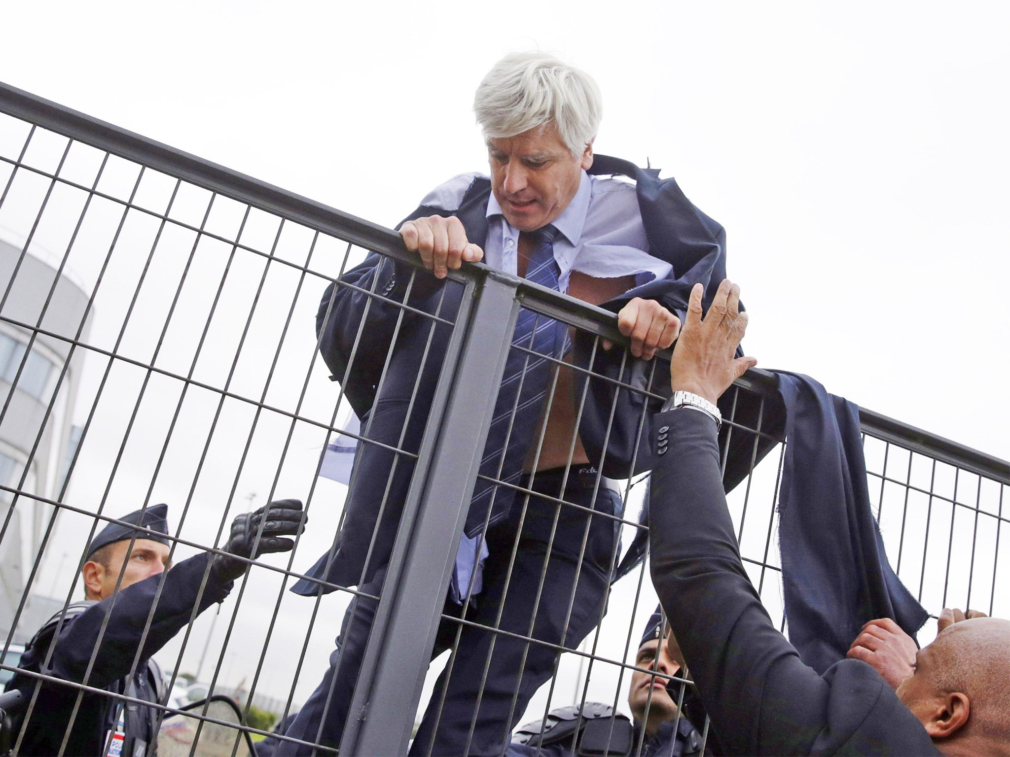 An Air France director, Pierre Plissonnier, climbs a fence to escape the mob