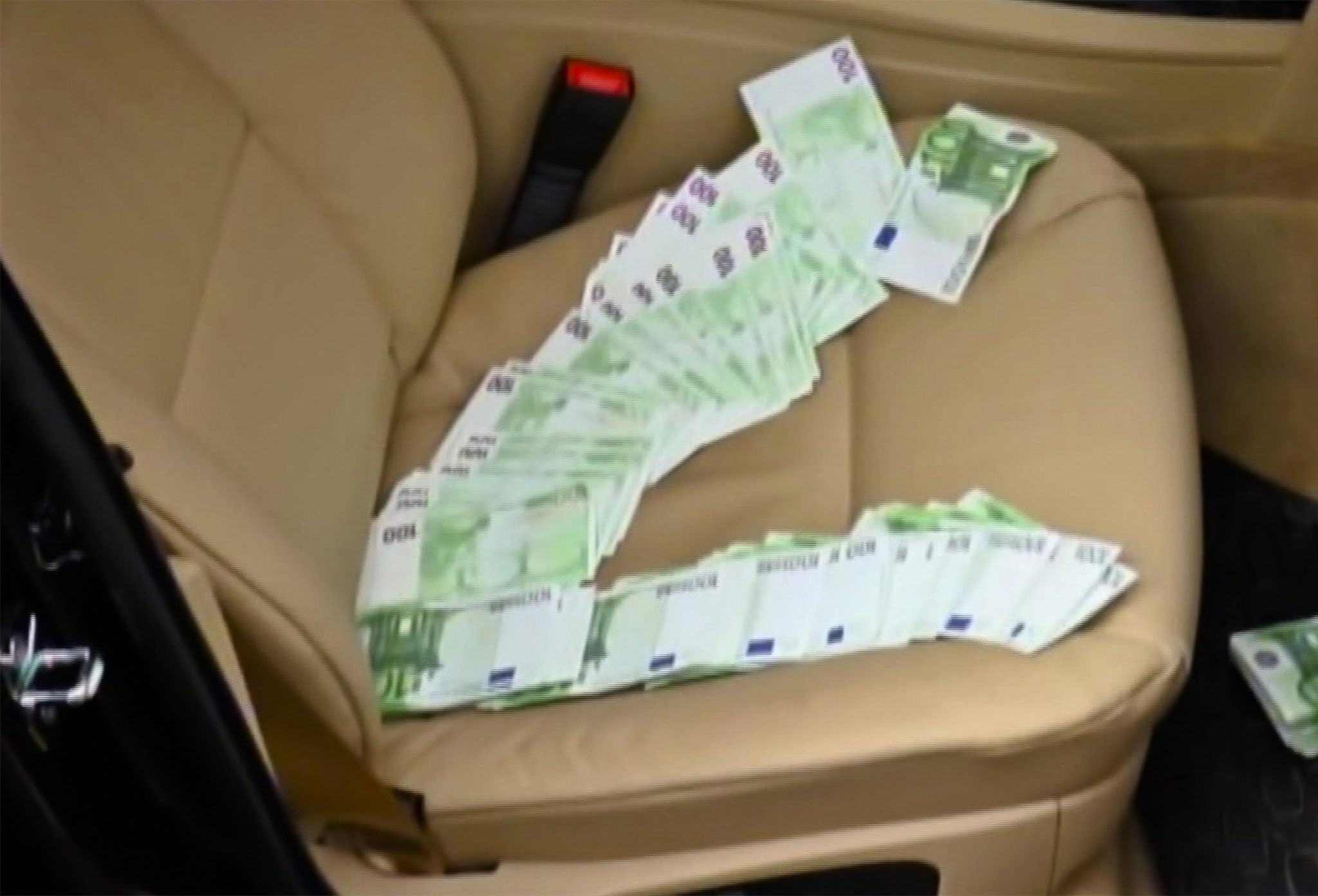 Euro banknotes laid out on the passenger seat of Grossu's car following his arrest