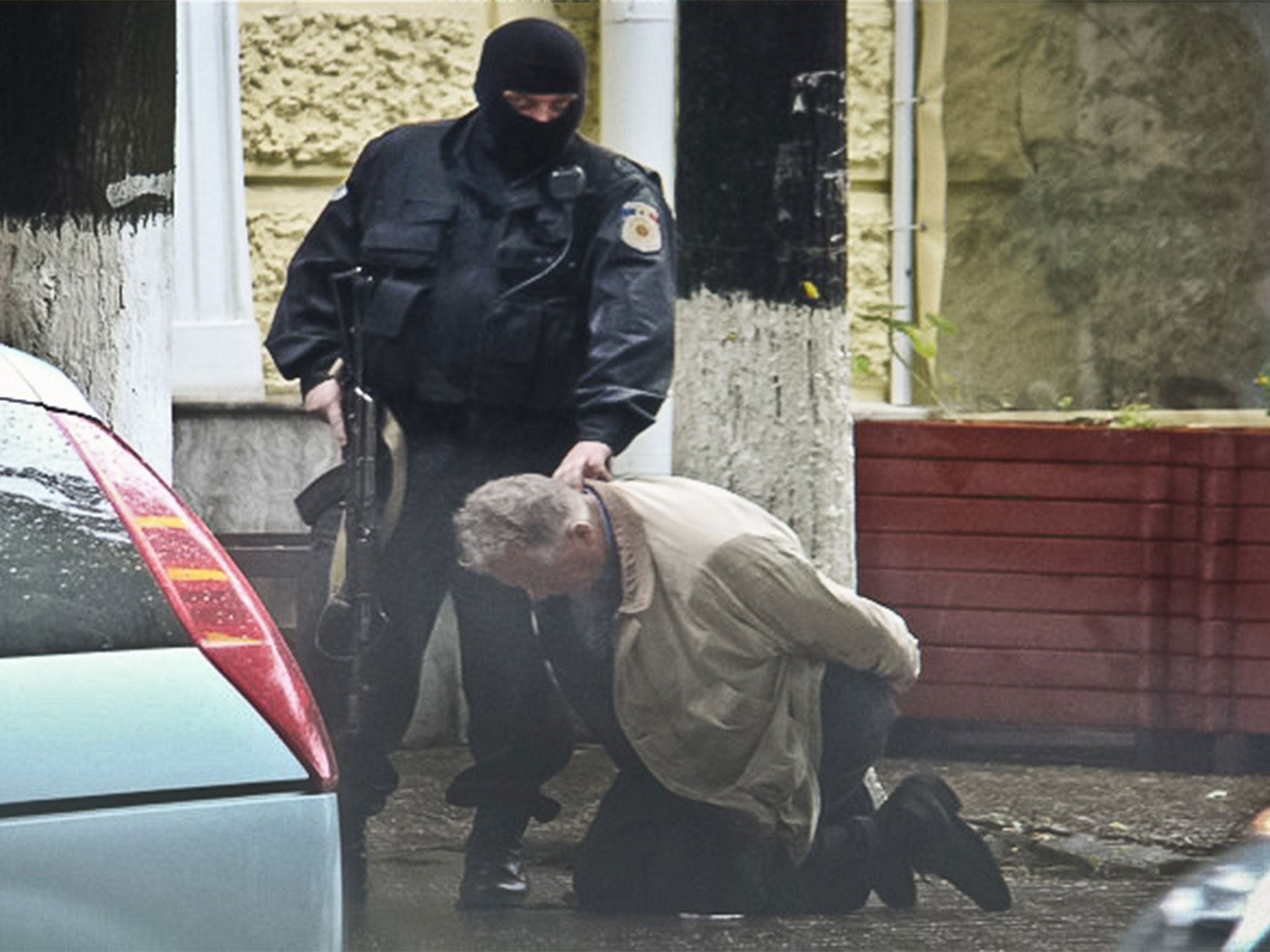 Gobetween Teodor Chetrus is held by Moldovan police during a uranium-235 sting operation