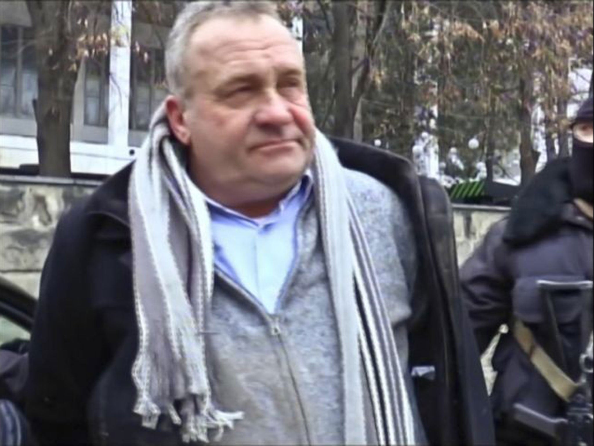 Valentin Grossu is escorted by an armed police officer following his arrest during a caesium smuggling sting operation in Chisinau, Moldova, on 19 February 2015