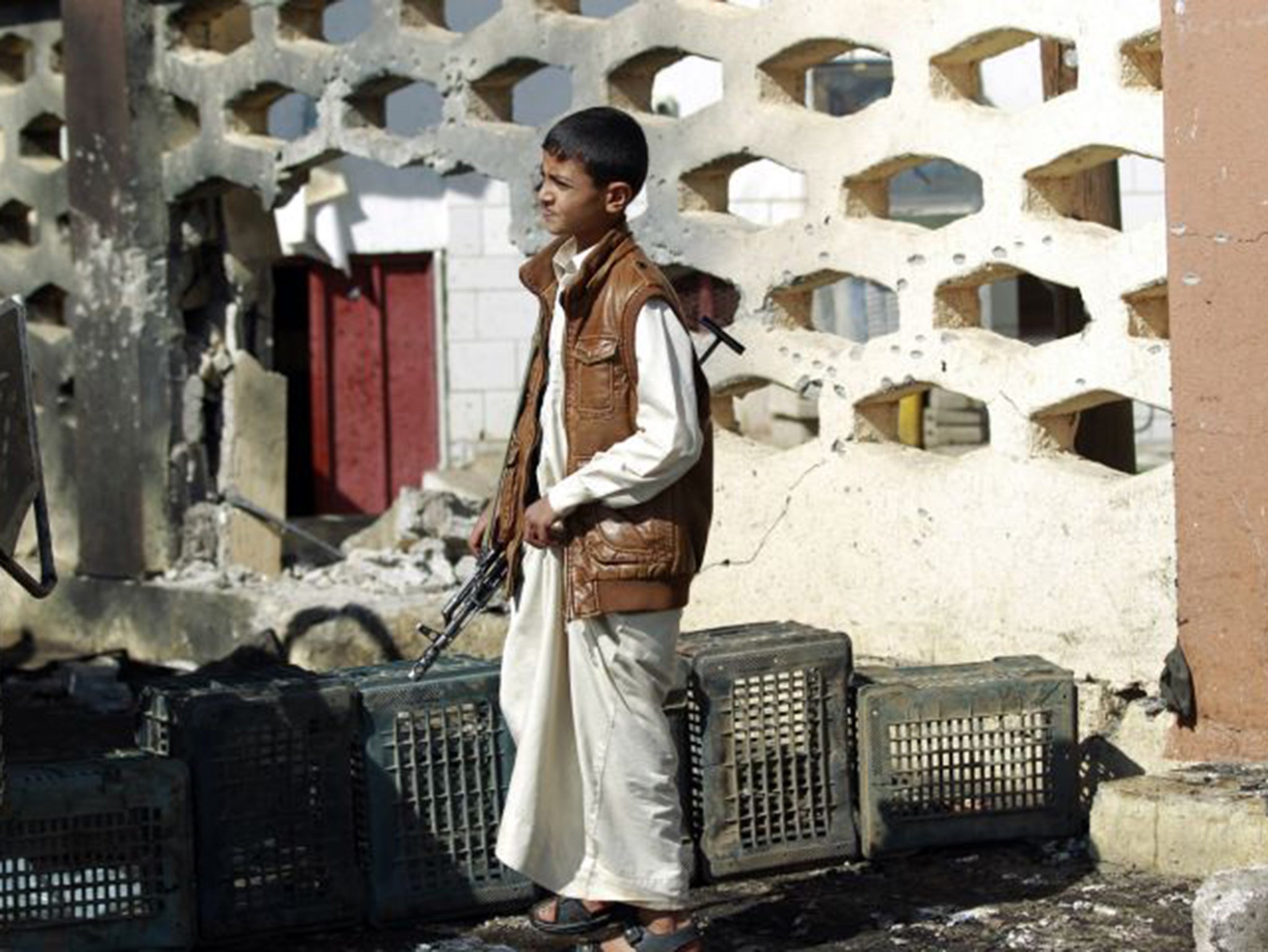 A Yemeni youth holds a weapon as he stands in front of the Al-Nour mosque after it was targeted by a suicide bombing in the capital Sanaa