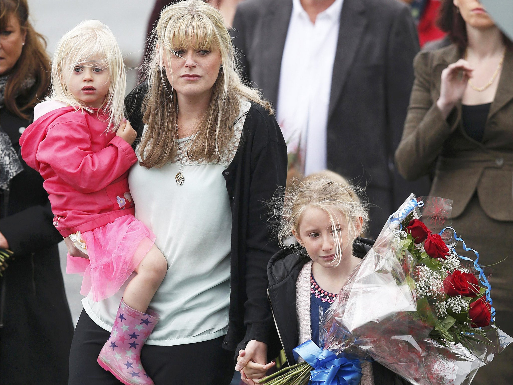 The widow of police officer Dave Phillips, Jen and their children Abigail, right, and Sophie arrive to lay floral tributes at Wallasey Dock Road, where PC Phillips was killed