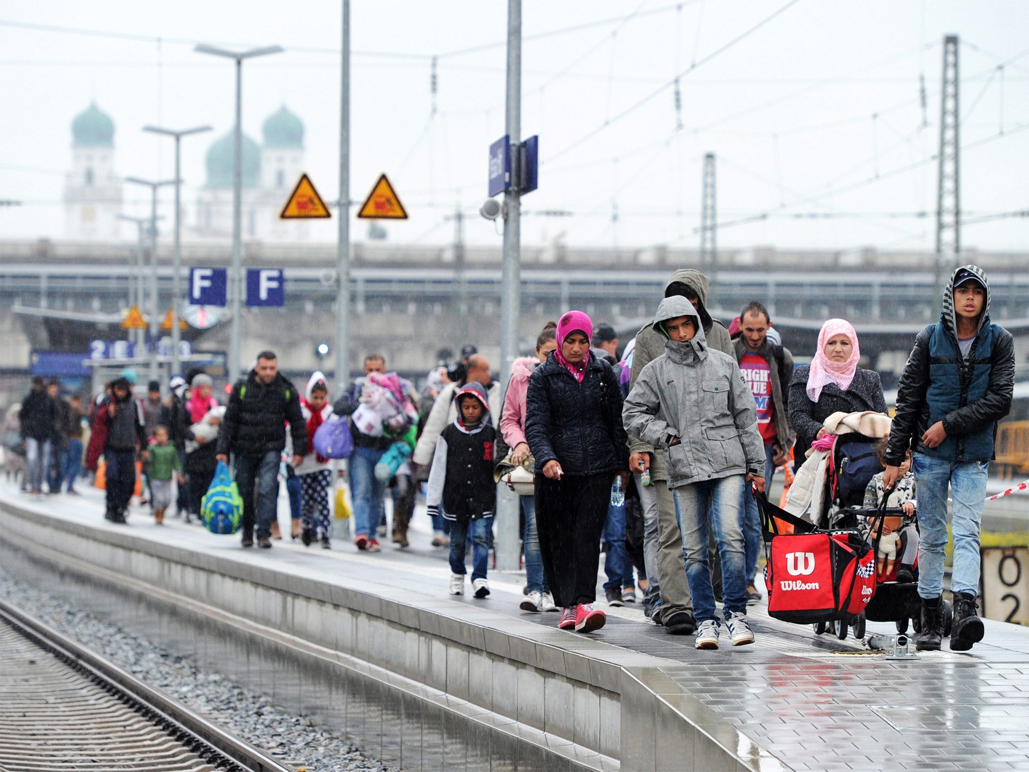 Refugees walk along the platform at the train station in Passau, Germany