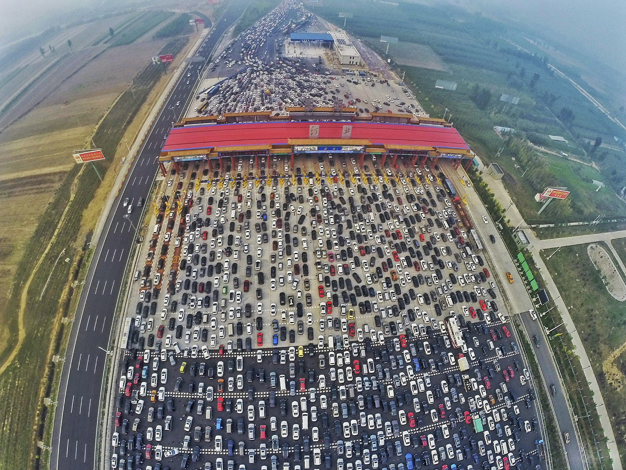 Vehicles are seen stuck in a traffic jam near a toll station as people return home at the end of a week-long national day holiday, in Beijing, China