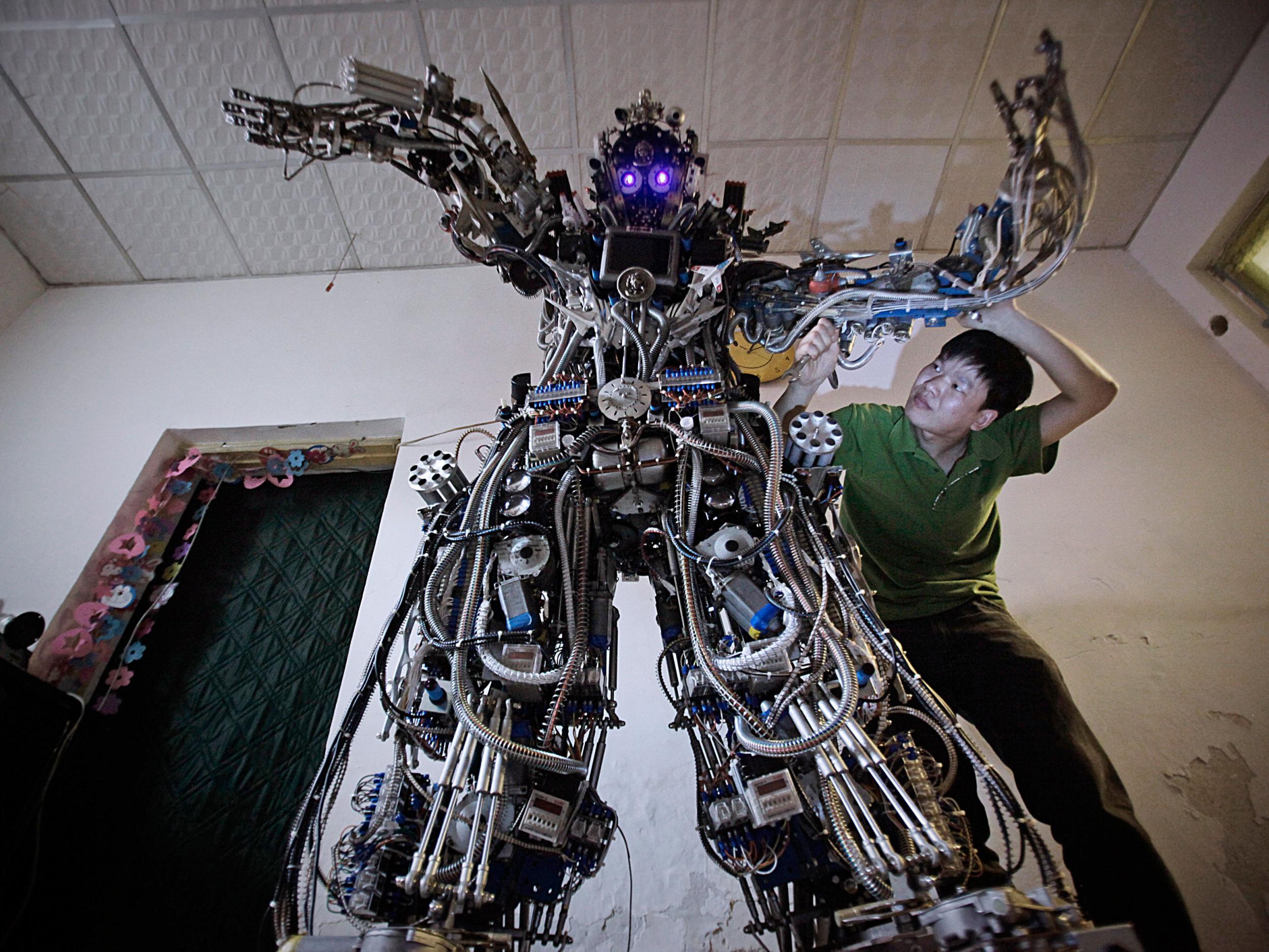 Chinese inventor Tao Xiangli modifies the circuits of his home-made robot at his house in Beijing, May 15, 2013