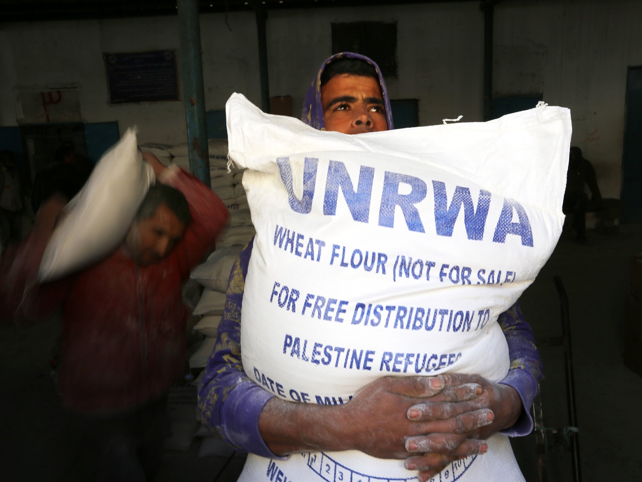 Palestinians receiving their monthly food aid at a UN distribution centre in the Rafah refugee camp, southern Gaza, earlier this year