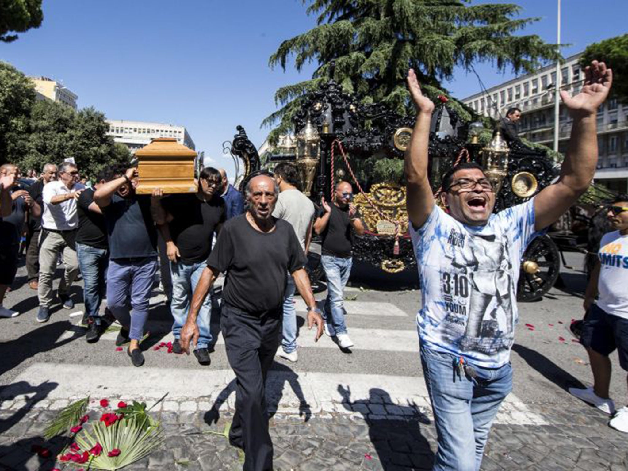 The coffin of mobster Vittorio Casamonica, 65, was paraded in a gothic horse-draw carriage on Thursday afternoon, while a hovering helicopter scattered rose petals from above and an orchestra played the theme music of The Godfather