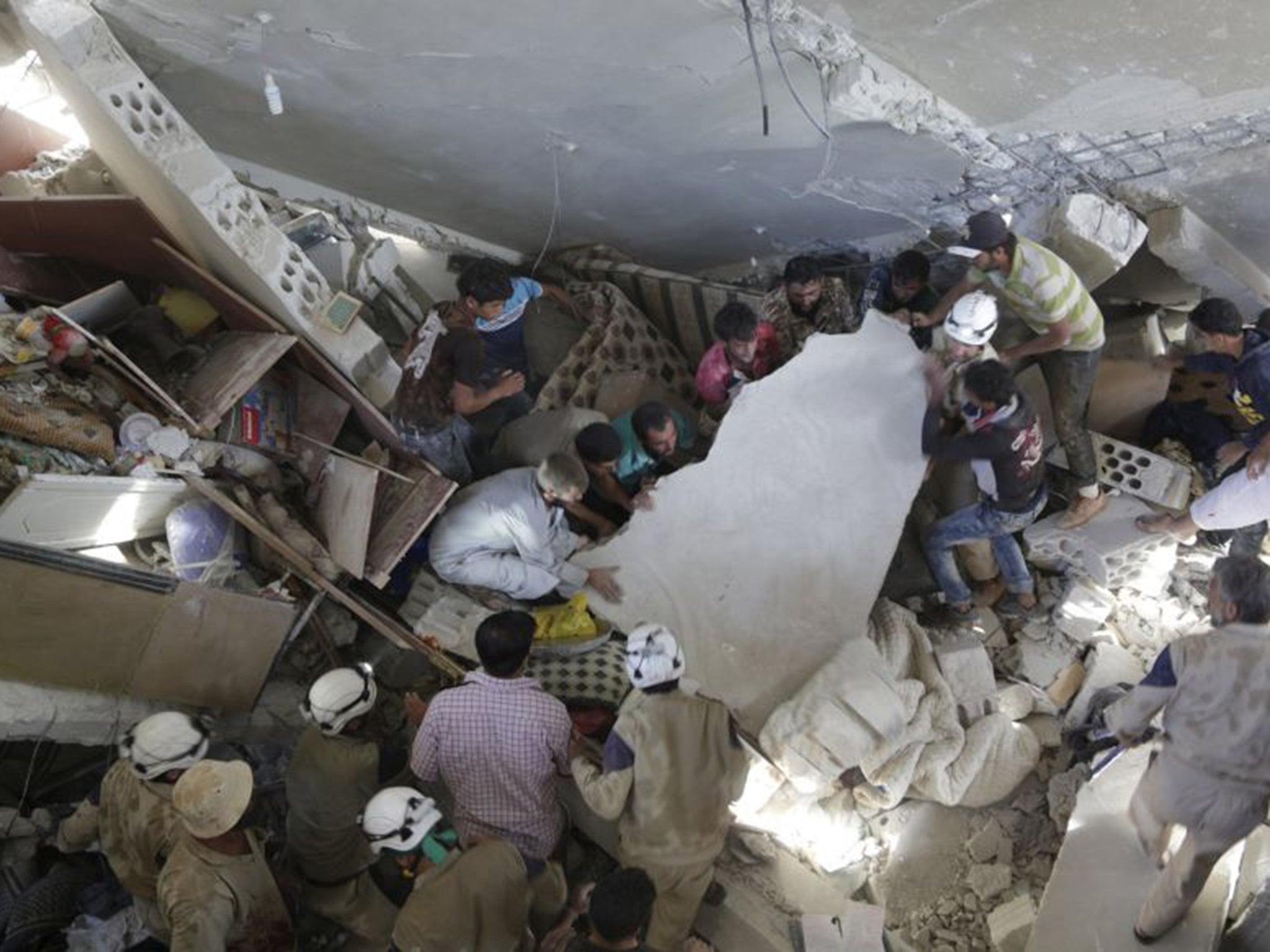 Civilians search for survivors under the rubble of a site hit by what activists said were cluster bombs dropped by the Russians in Maasran town, south of Idlib