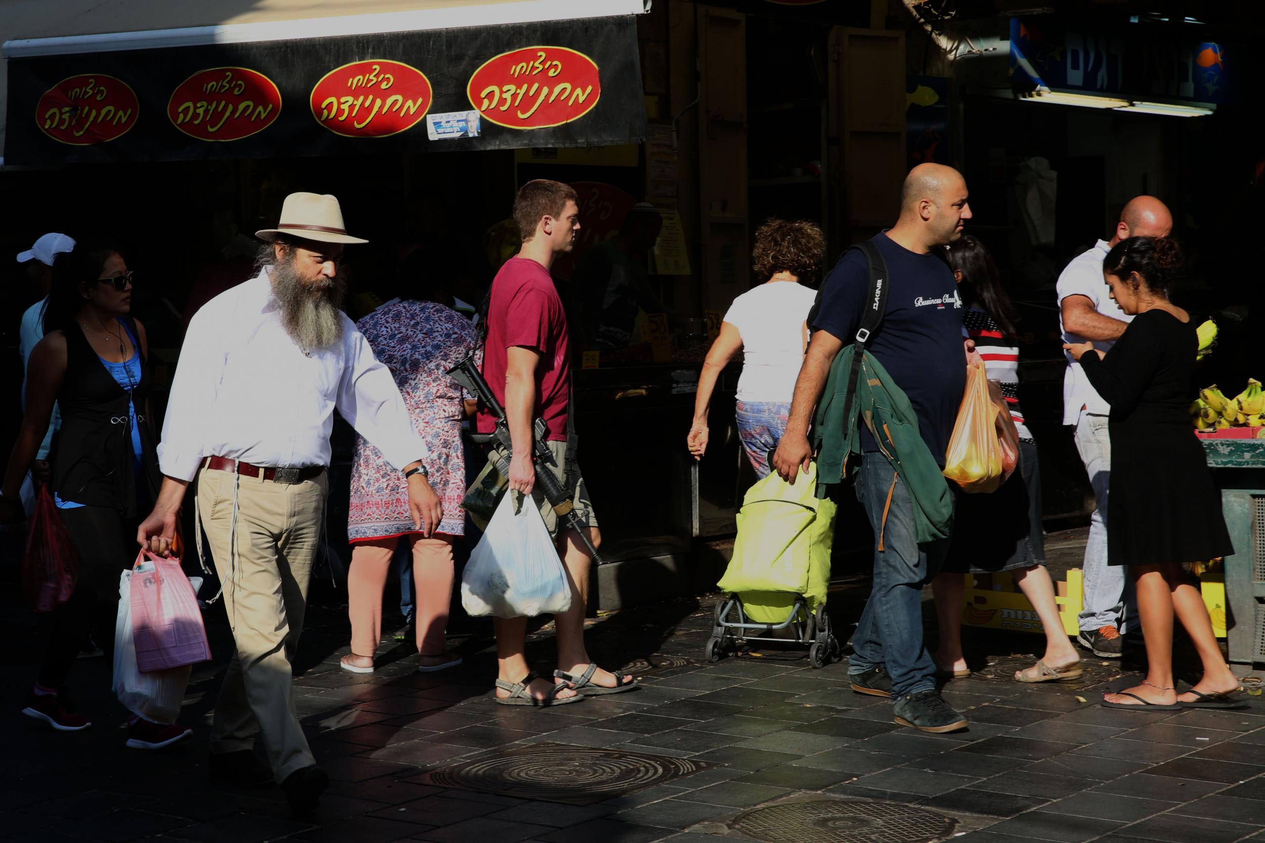 Young Israelis (mostly soldiers on weekend vacation) carry their personal rifles at the Jerusalem outdoors