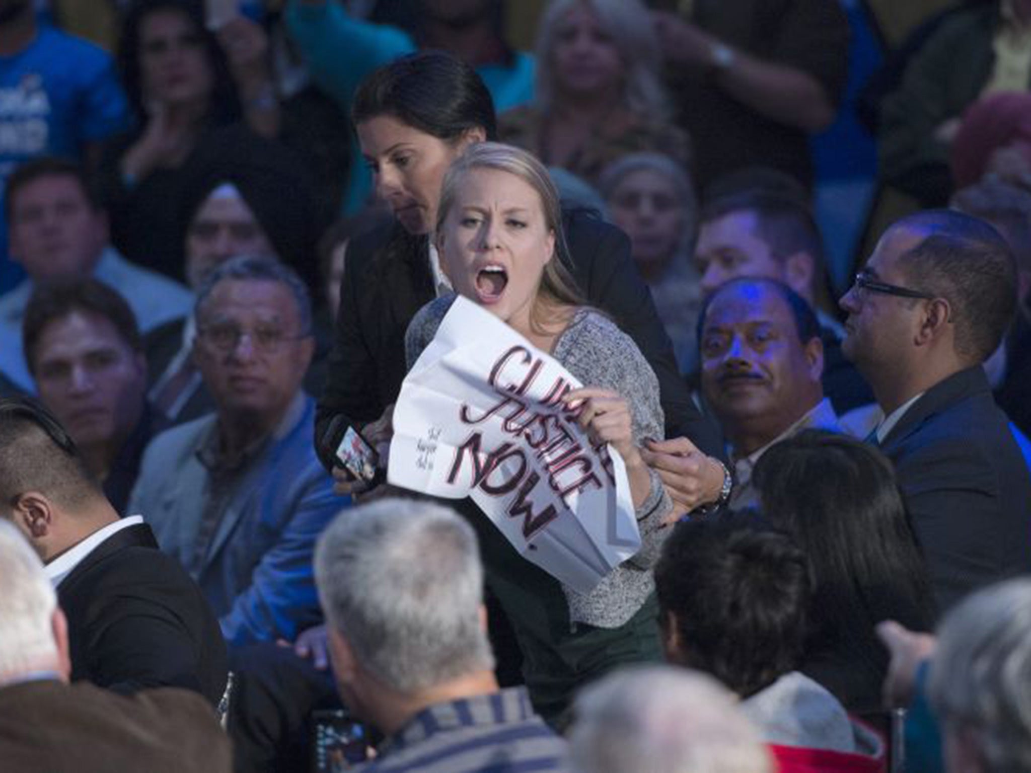 Members of the RCMP grab a protester during a campaign event by Conservative leader Stephen Harper in Surrey, British Columbia,