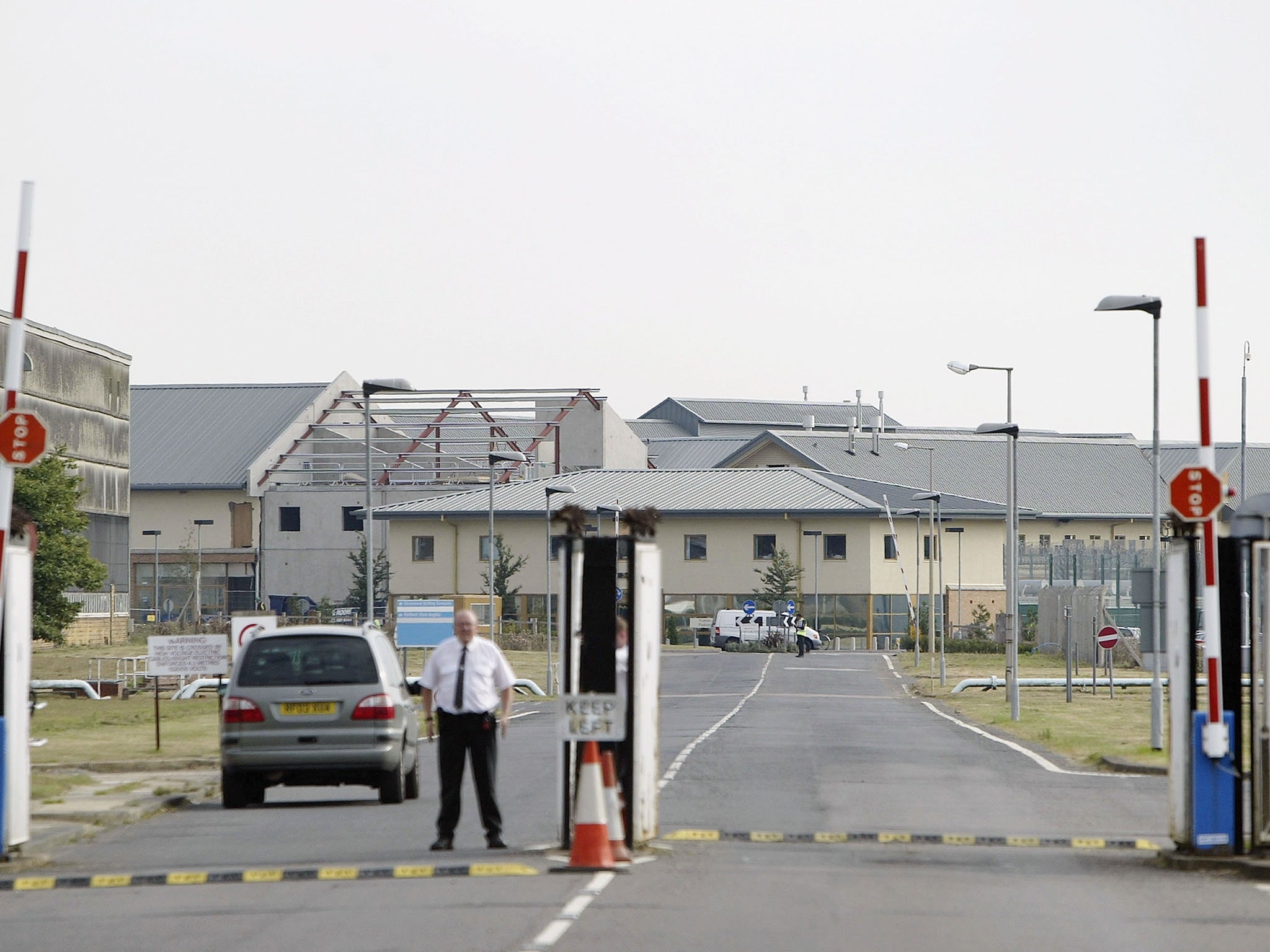 A security guard stands at the gates of the The Yarl's Wood Immigration Cente