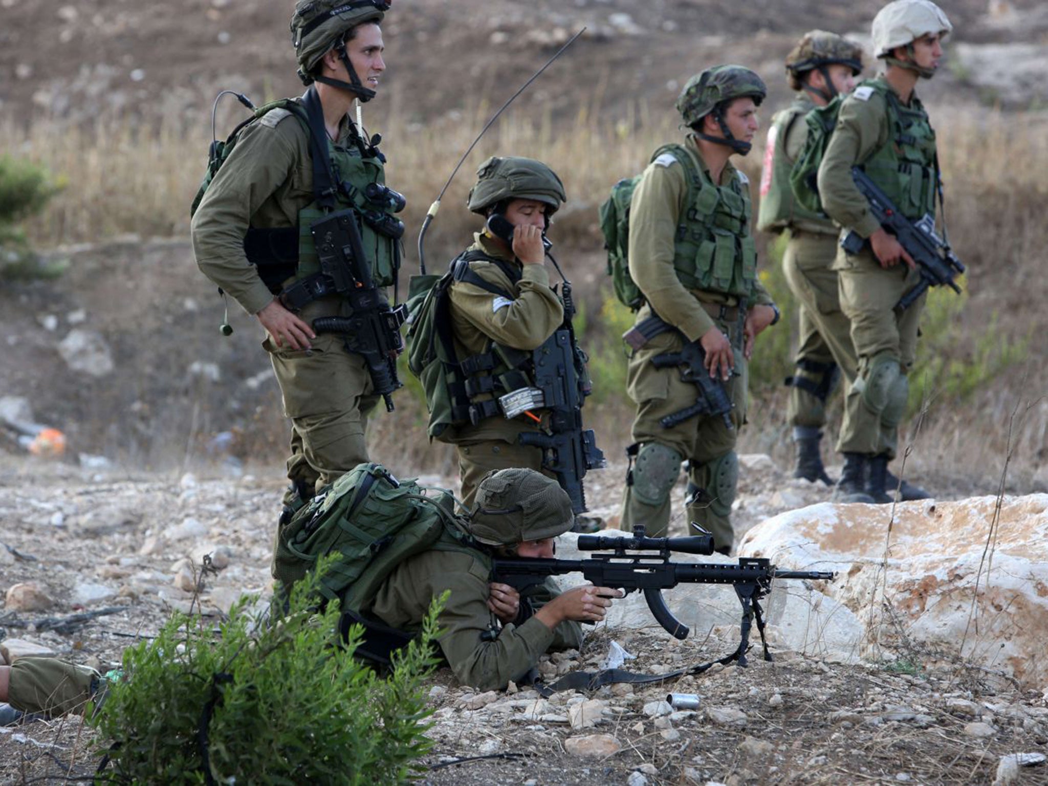 An Israeli soldier aims at Palestinian protesters during clashes at the Israeli-maned Hawara checkpoint, south of the West Bank city of Nablus