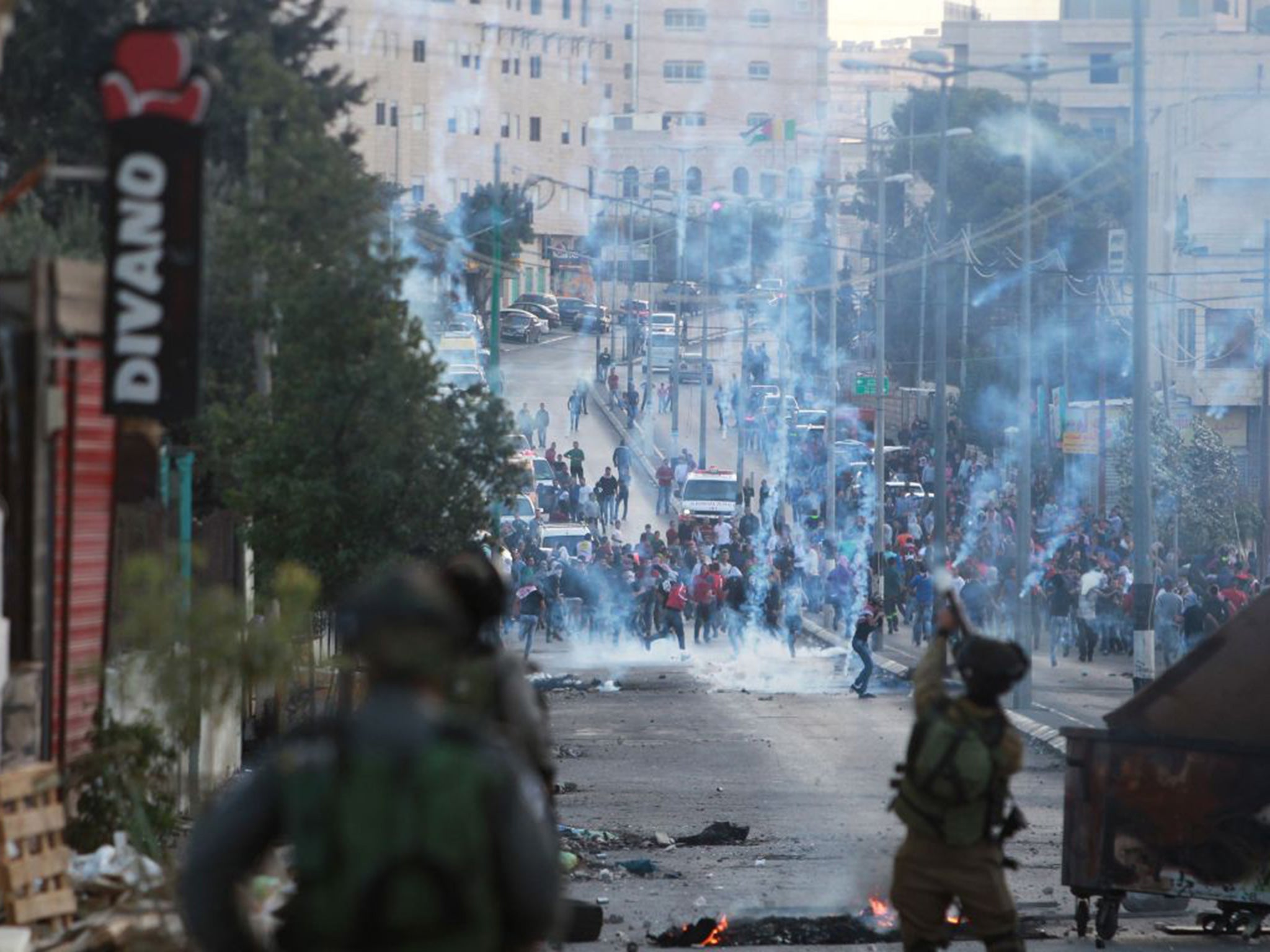 Israeli security forces fire tear gas grenades towards Palestinian demonstraters during clashes in Bethlehem