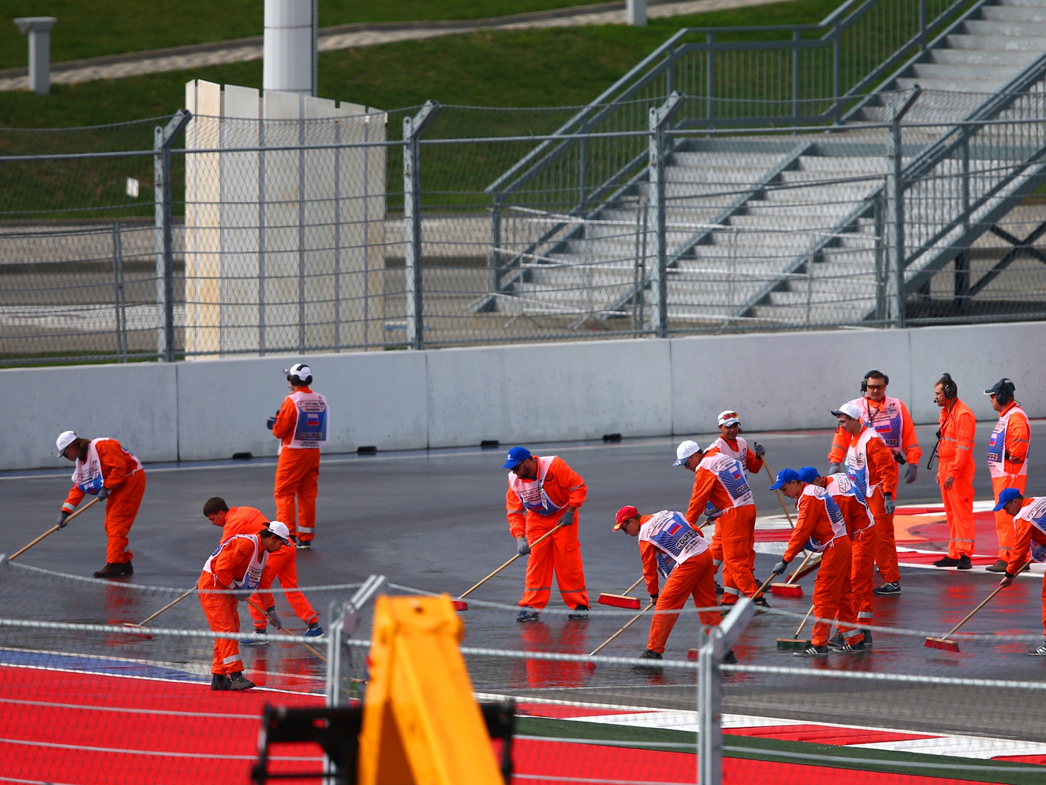 Marshals clean up a diesel spillage on the Sochi Autodrom circuit