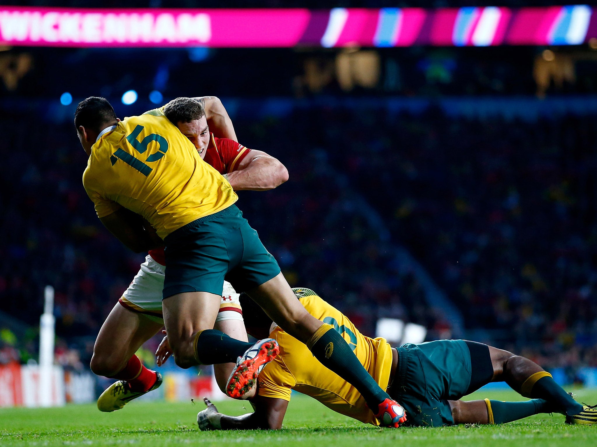 Wales' George North is tackled by Israel Folau and Tevita Kuridrani