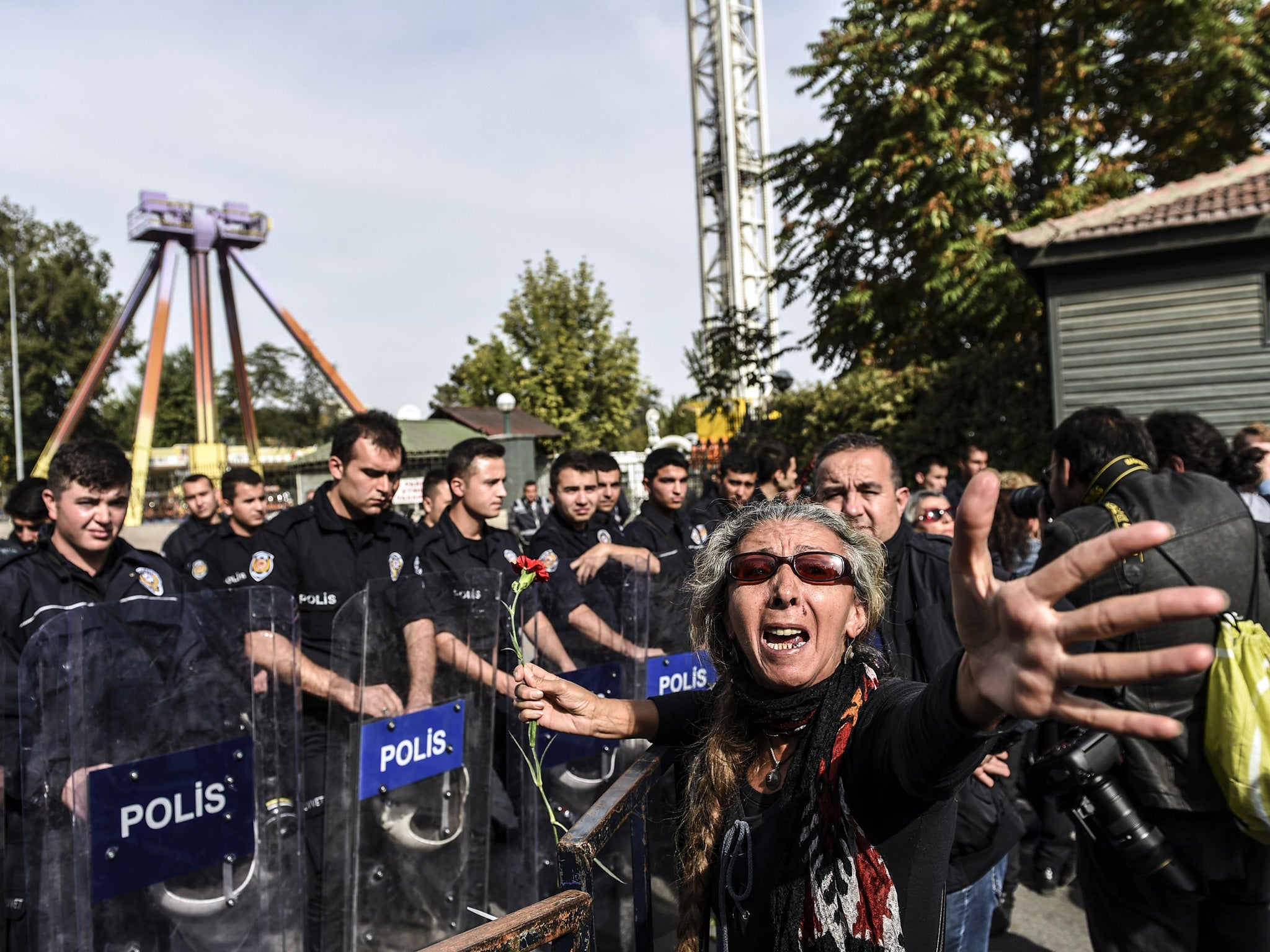 A woman reacts near a row of police officers blocking the way to the site of yesterday's twin bombings during a rally to remember the victims