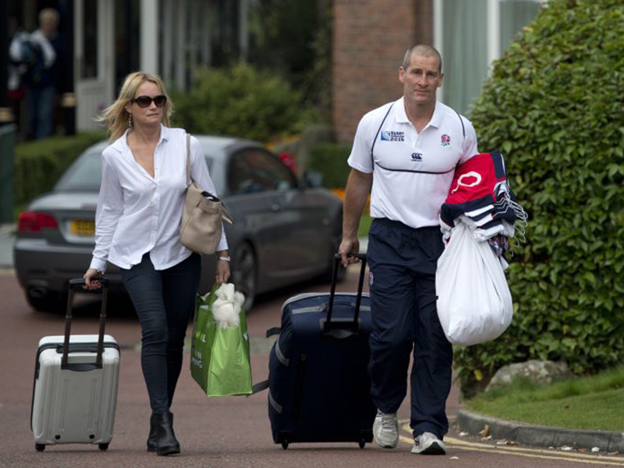 England coach Stuart Lancaster leaves the team hotel in Worsley yesterday with his wife Nina