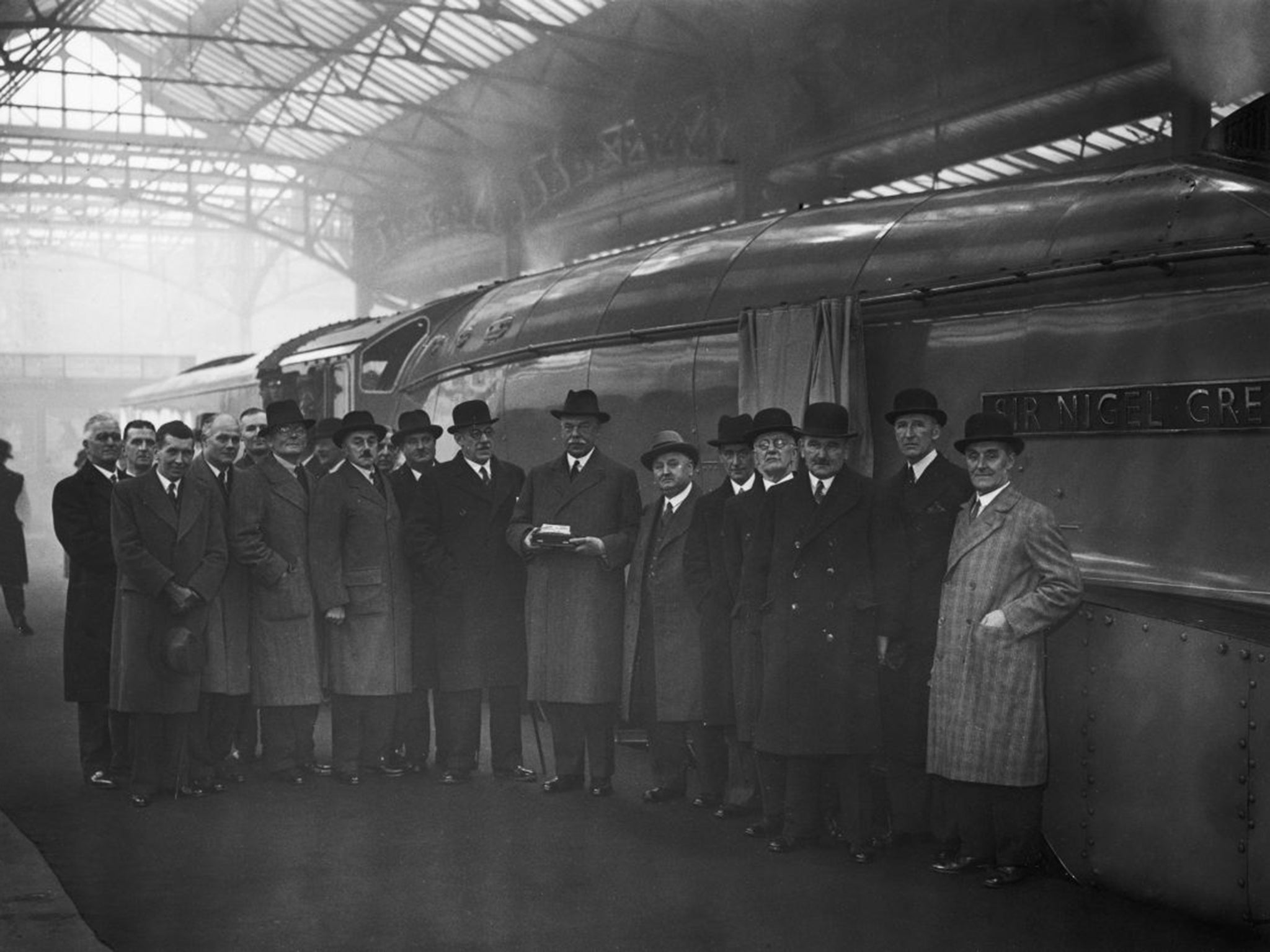 Sir Nigel Gresley, centre, holds a silver model of his locomotive creation in 1937 (Getty Images)