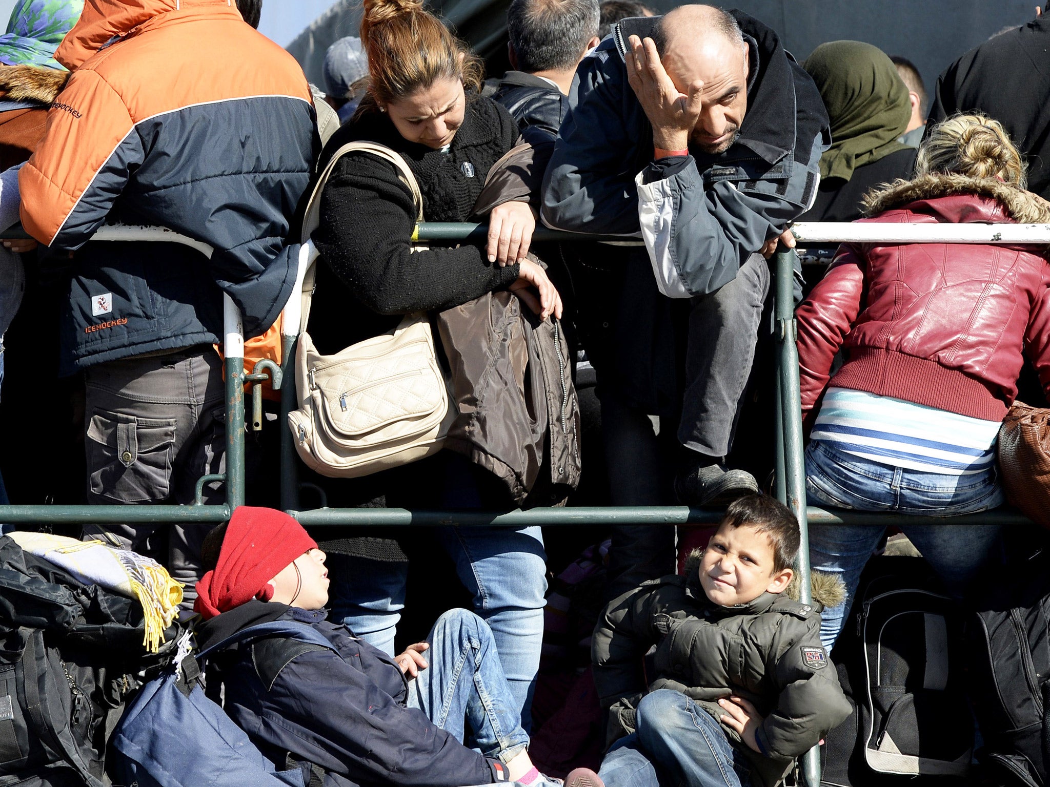 Refugees wait for a bus near the central rail station in Passau, southern Germany