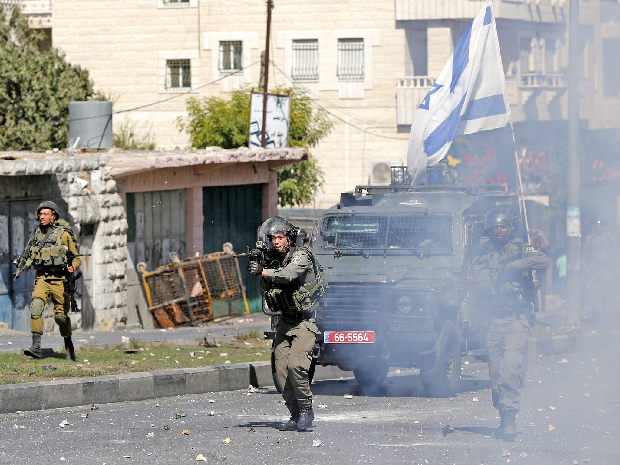 Members of the Israeli armed forces take up positions during clashes with Palestinian protesters in Hebron