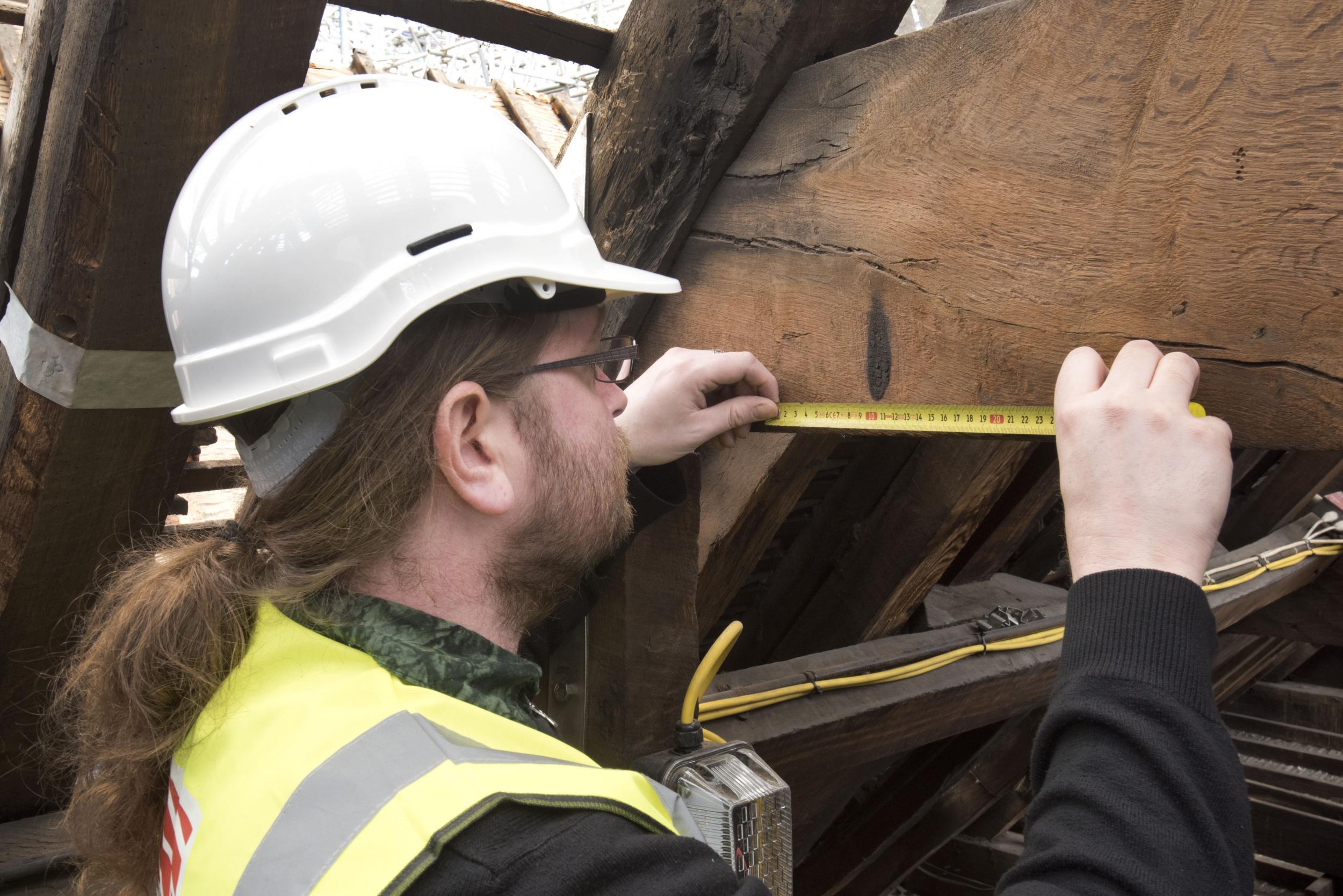 MOLA archaeologist, James Wright, inspects apotropaic scorch marks at Tower of London,