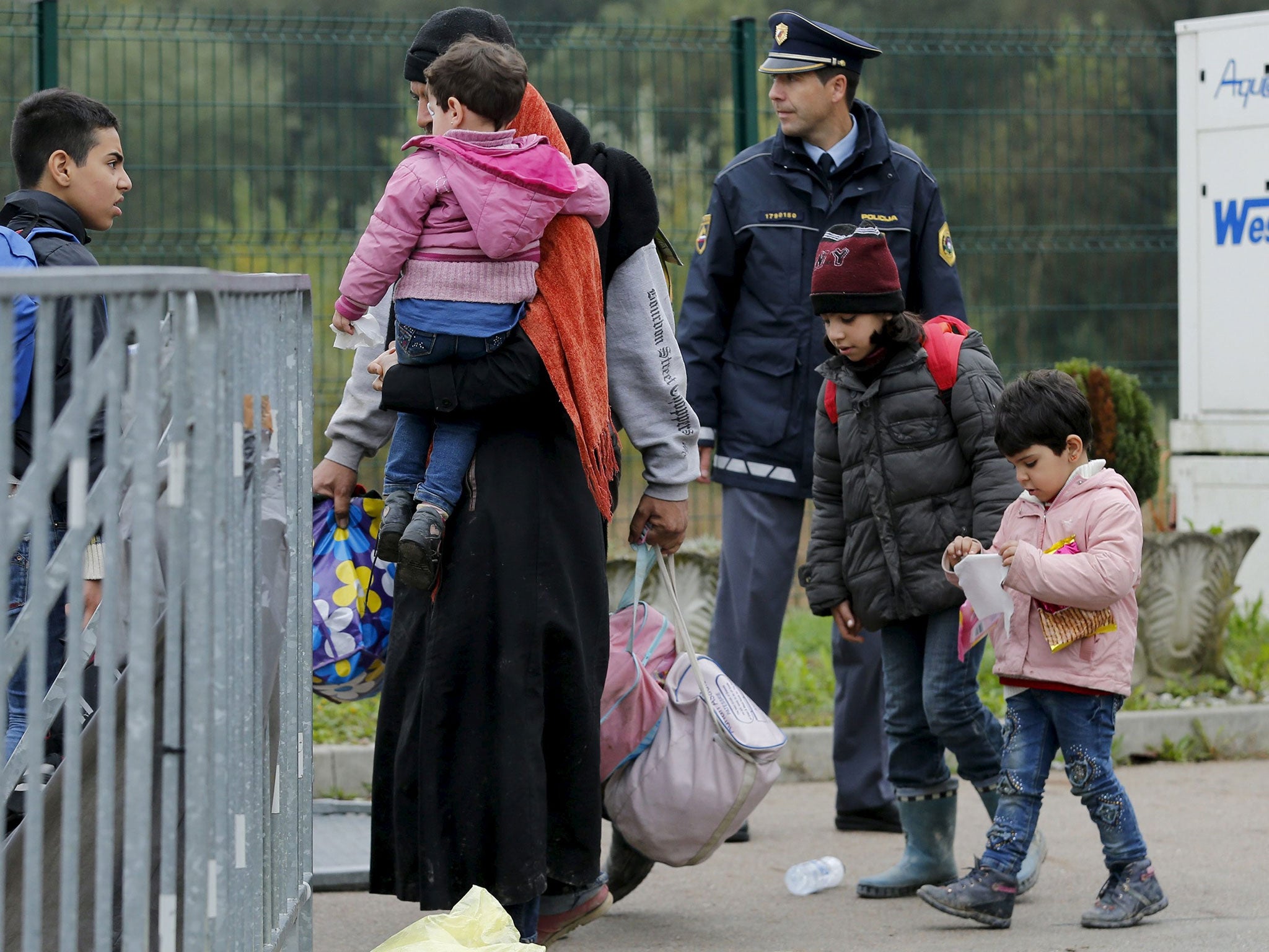 A family walks to a registration center at a Croatia-Slovenia border crossing in Lendava, Slovenia October 17, 2015.