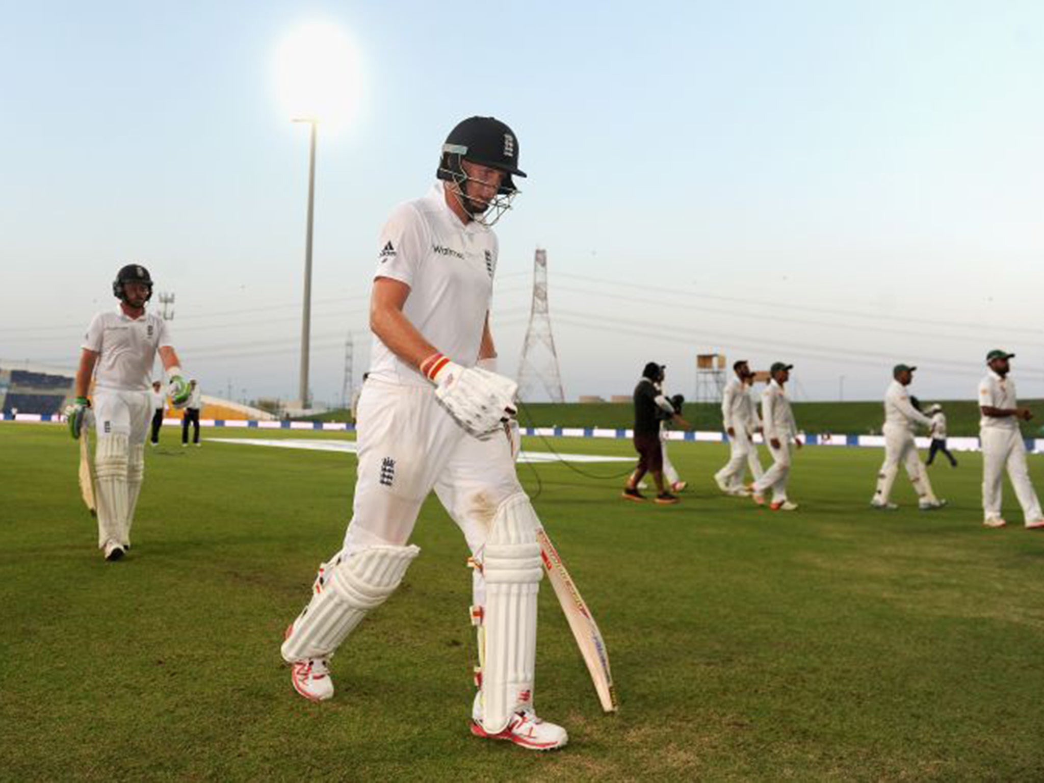 Joe Root and Ian Bell leave the field at the Dubai International Cricket Stadium owing to bad light